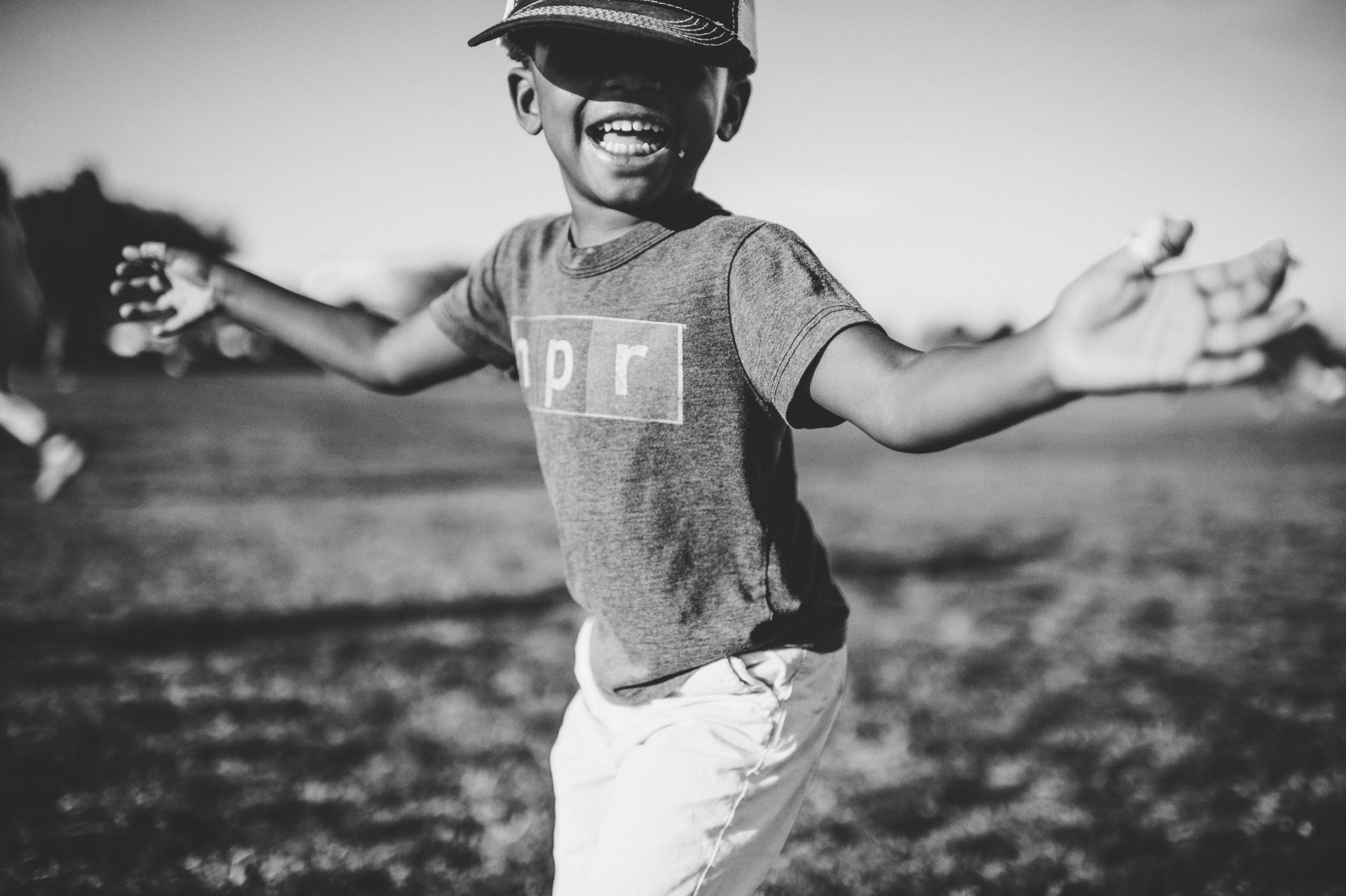 balck and white image of small boy running in open field