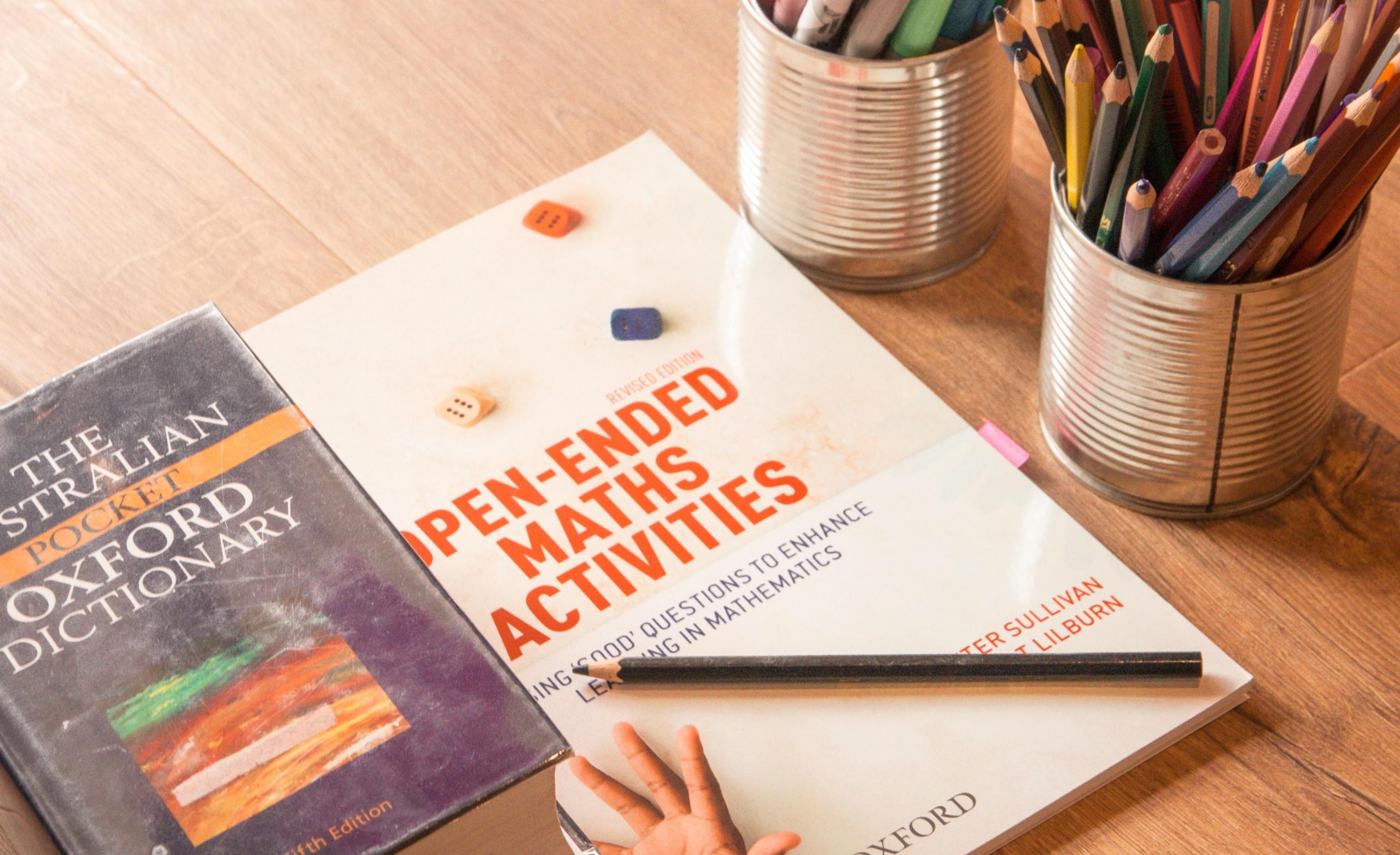 mathematics text book on desk next to staionery