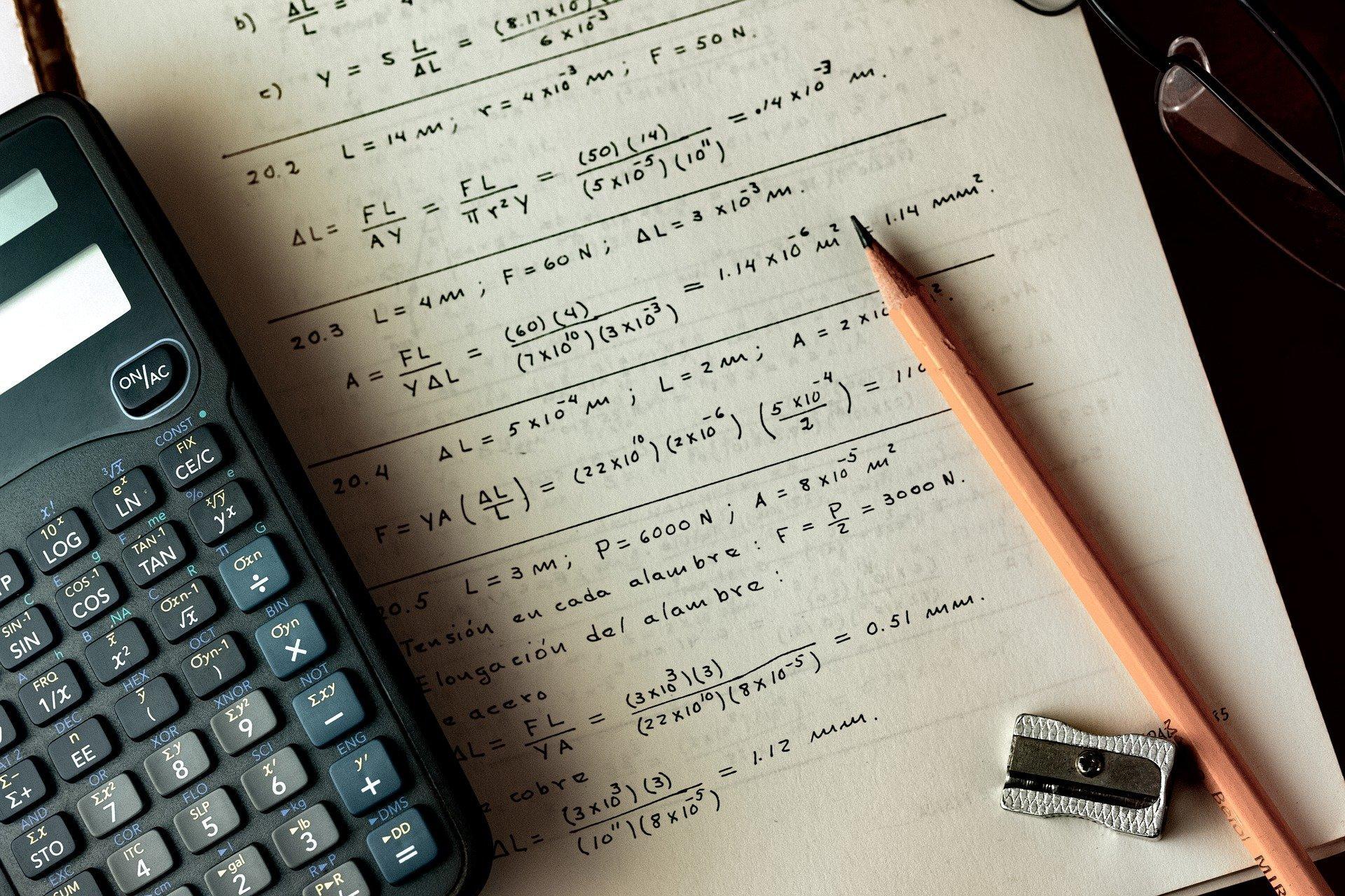 maths exercise book, pencil and calculator