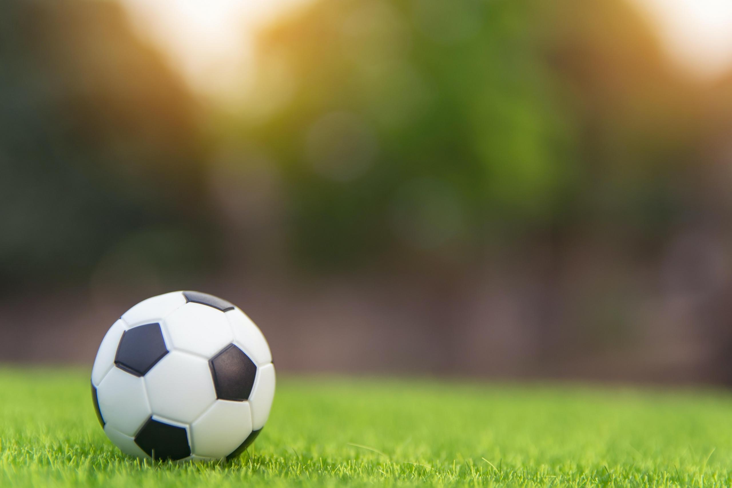 black and white soccer ball on green pitch