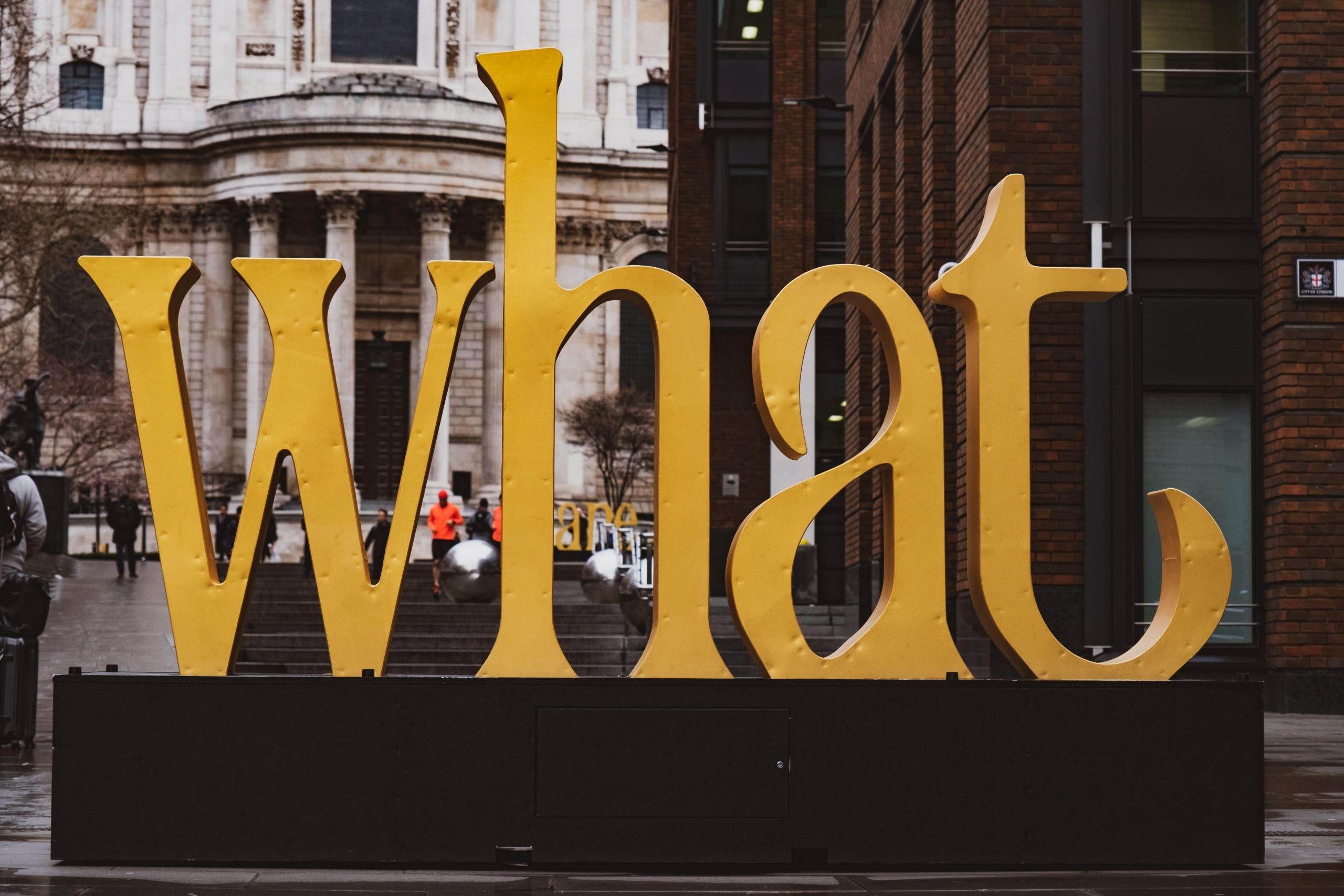 yellow sculpture spelling the word what