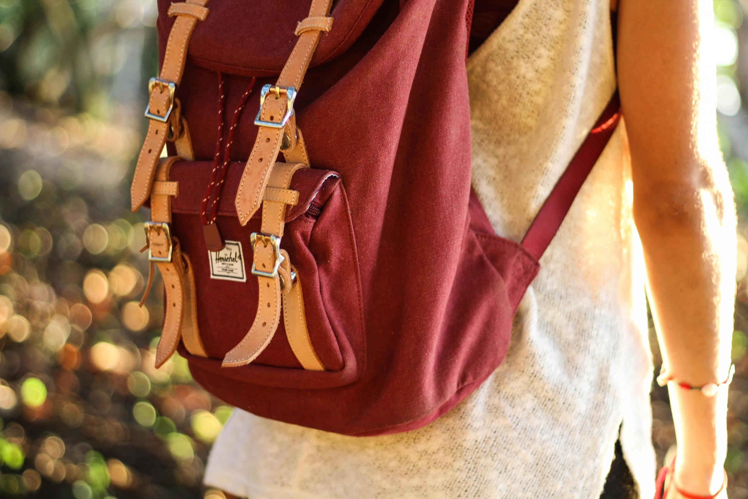 female student carring burgundy backpack
