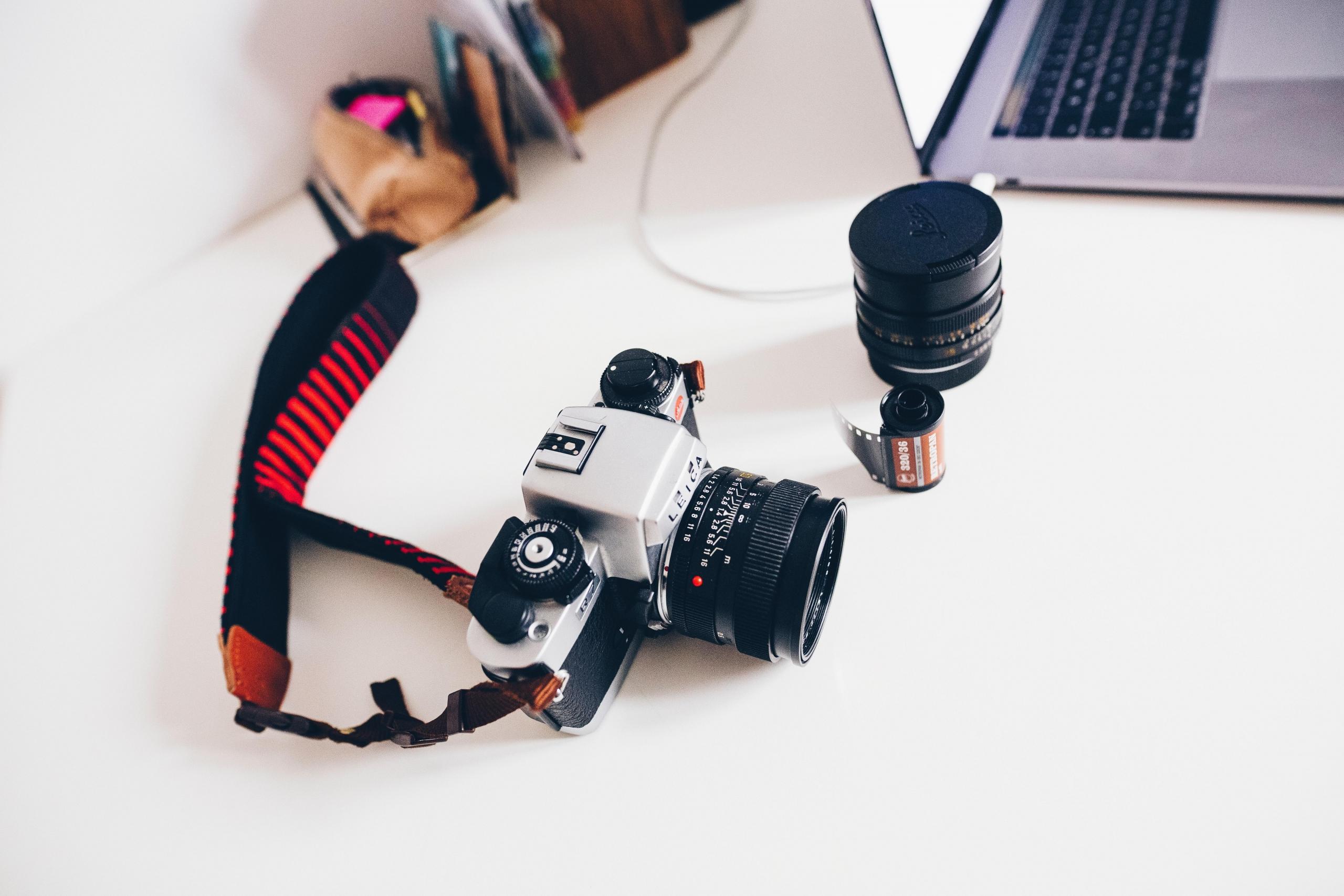 laptop, camera, spool an lens on desk
