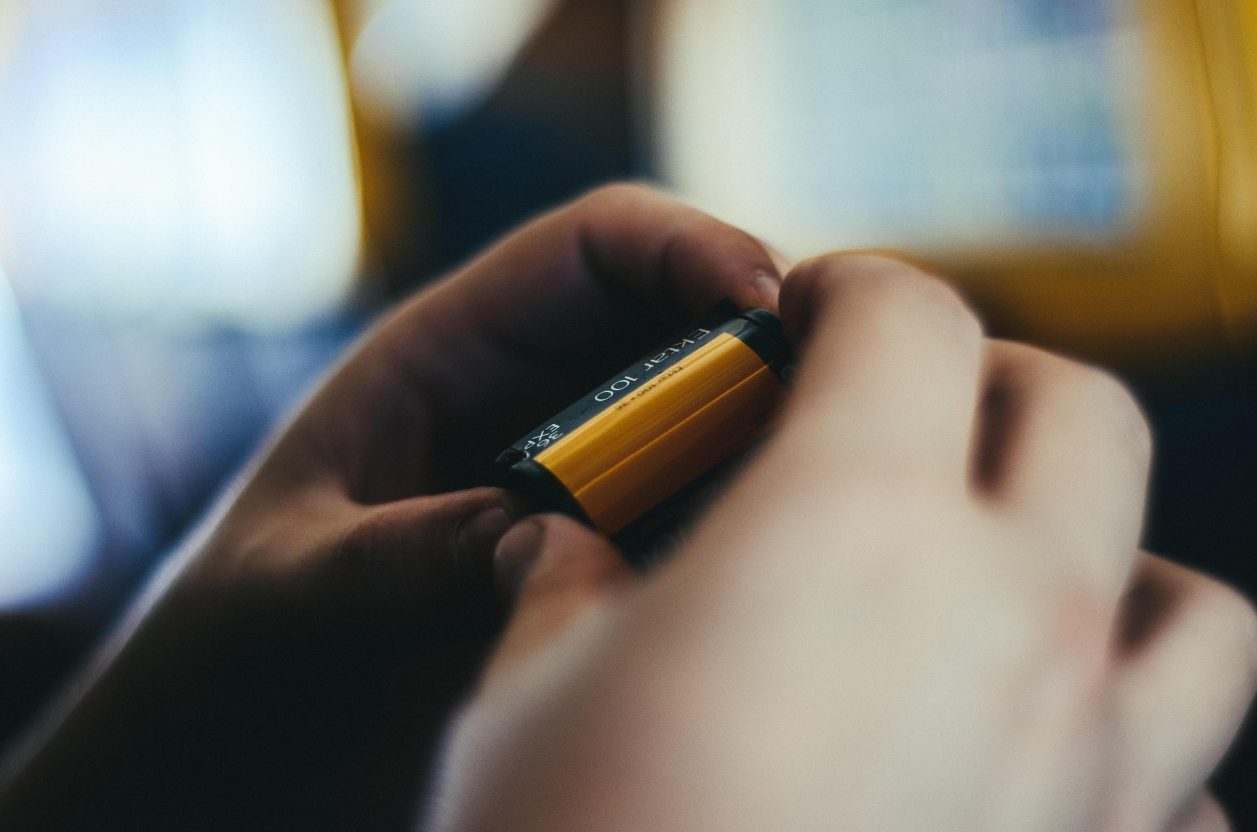 person holding spool of camera film