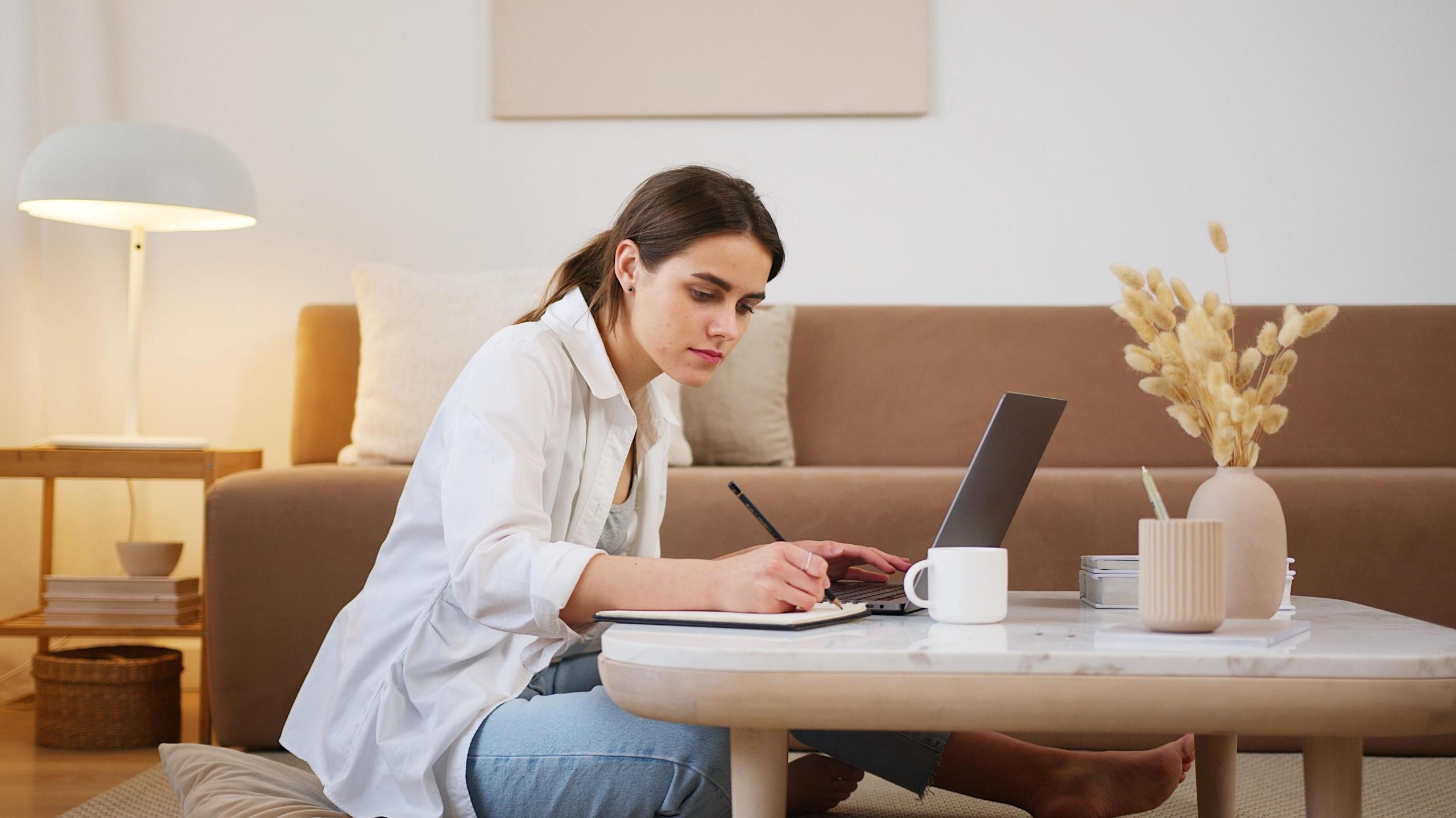 student making notes in living room