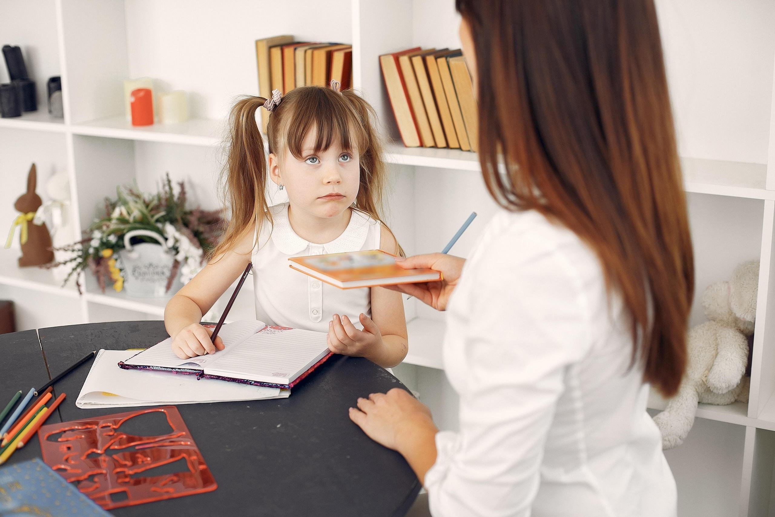woman handing book to child
