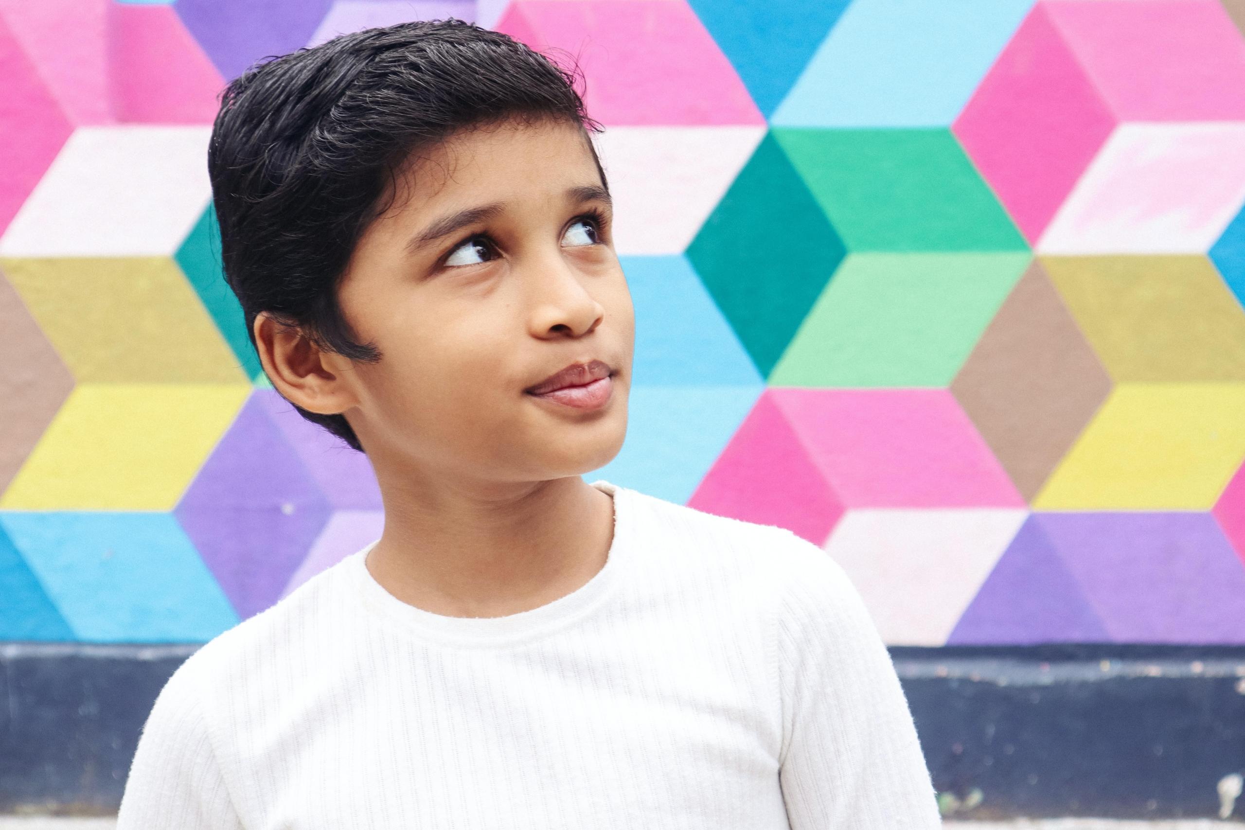 boy standing infront of colourful wall