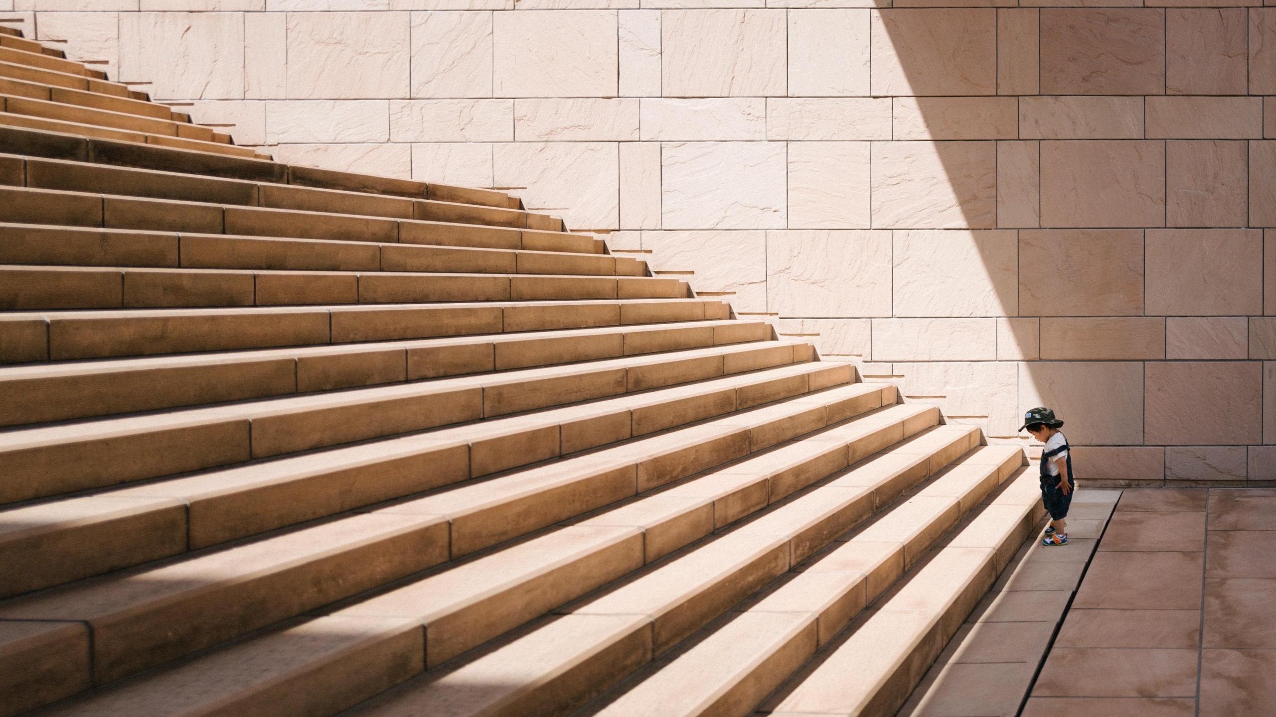 small boy at the bottom of large staircase