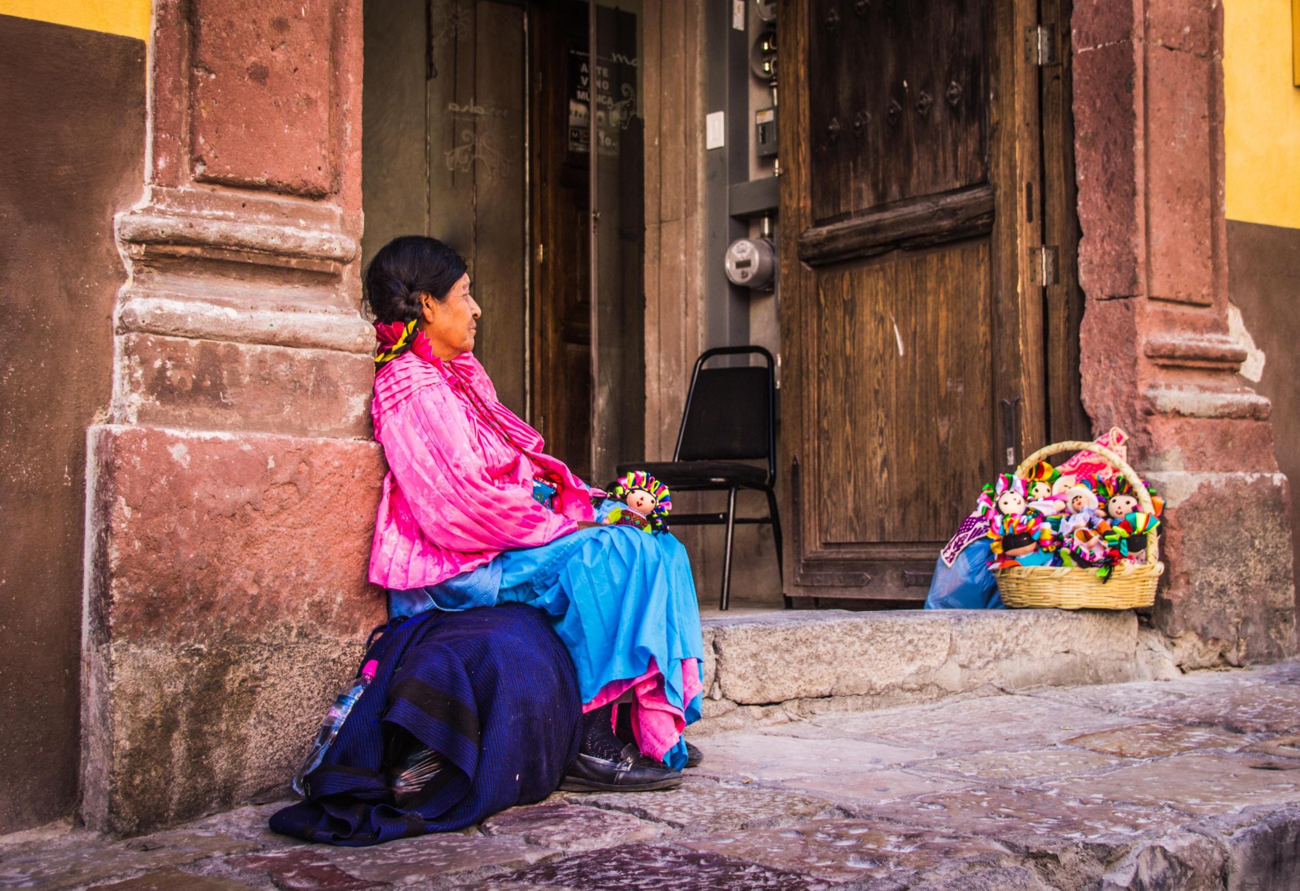 brightly dressed woman seated on floor