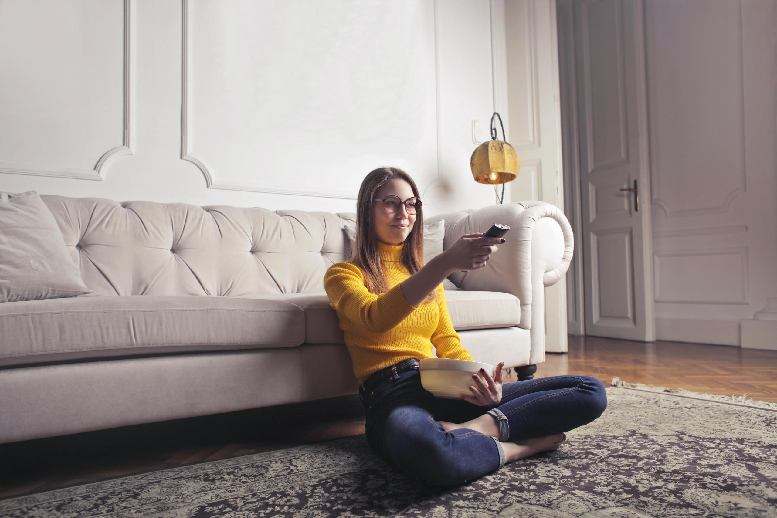 woman sitting on floor using remote control