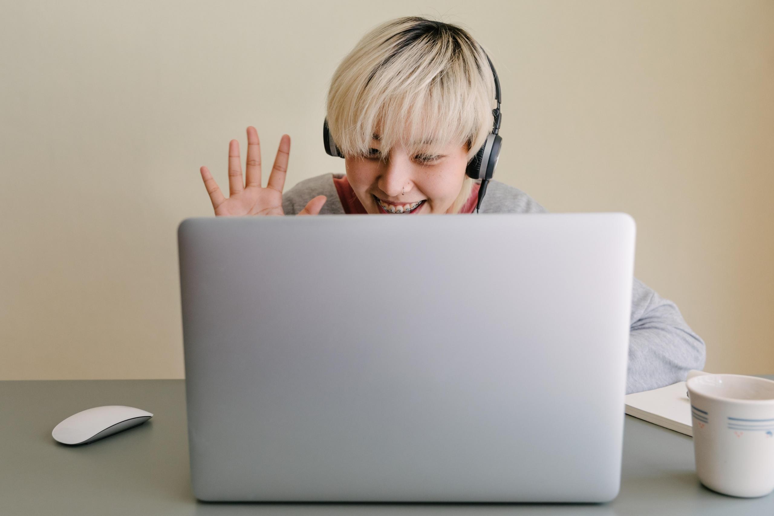 boy wearing headphones and using laptop for a call