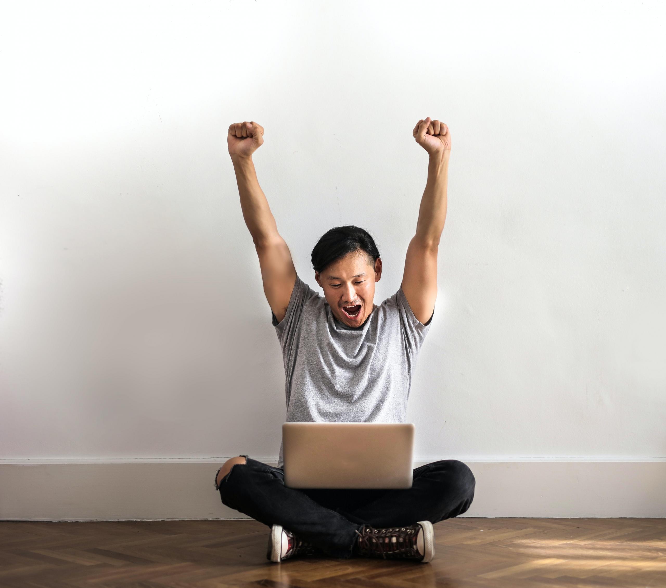 man on ground raising arms up in triumph