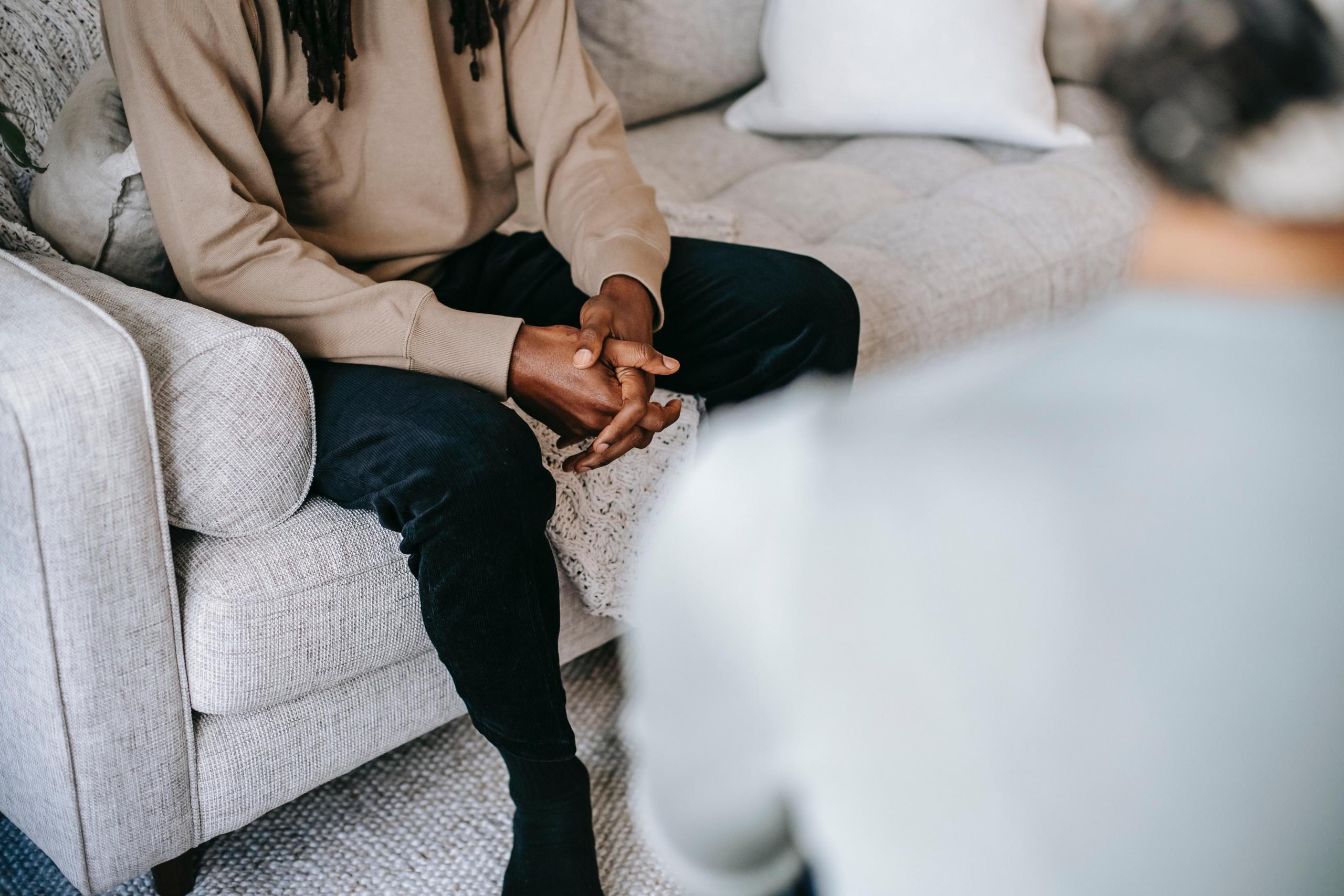man sitting on couch talking to counsellor