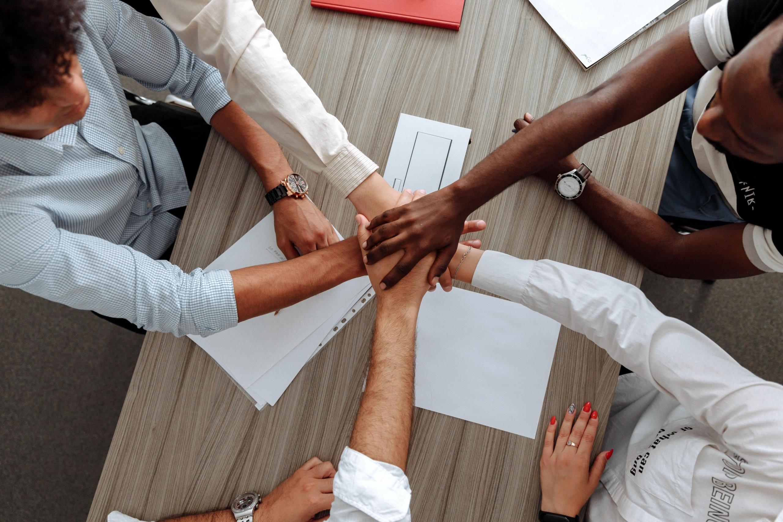 team of people stacking hands together