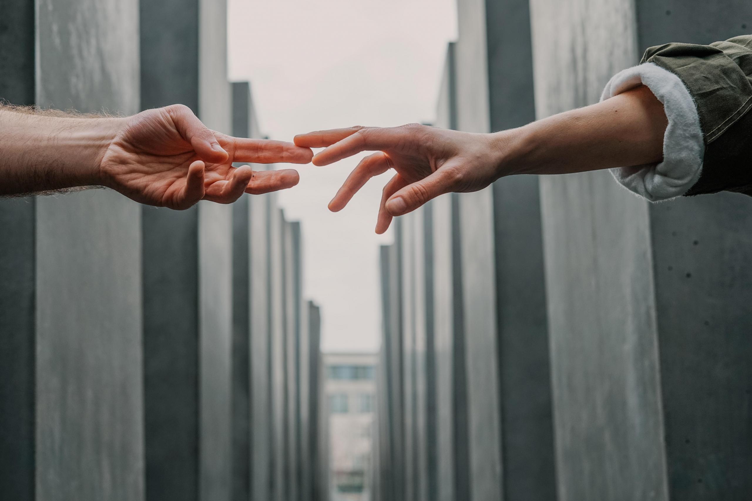 two people stretching out their hands to each other