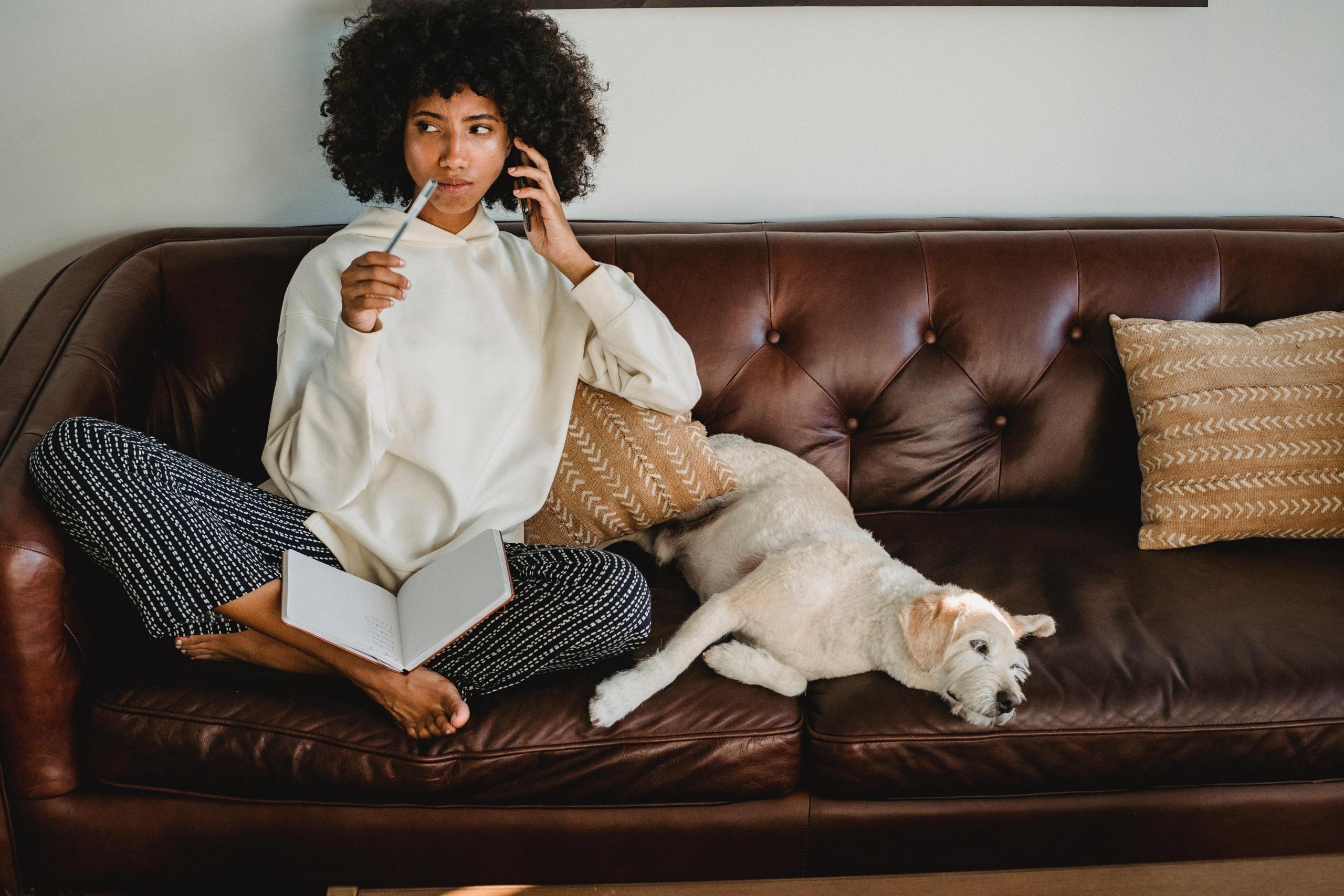 woman on phone and writing in notebool