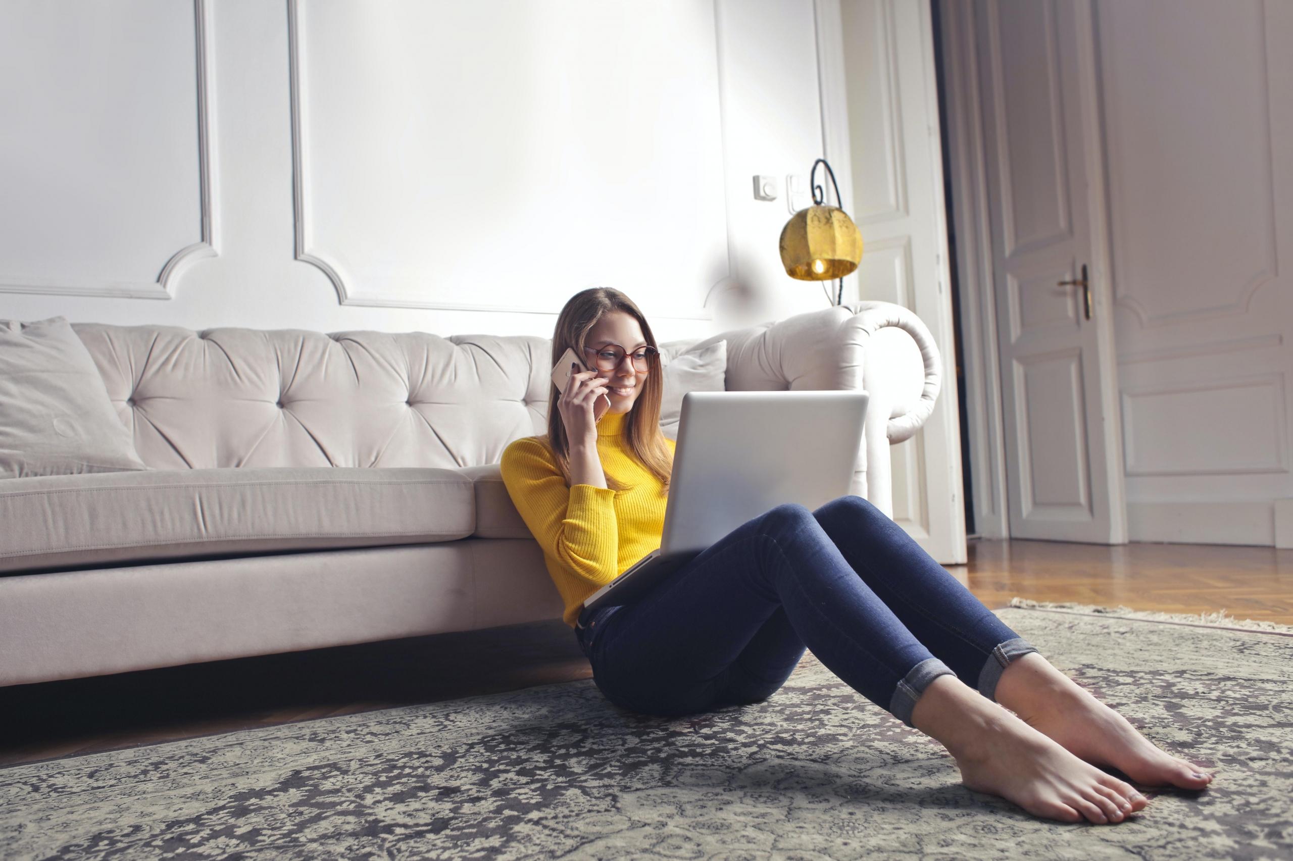 woman talking on phone and using laptop