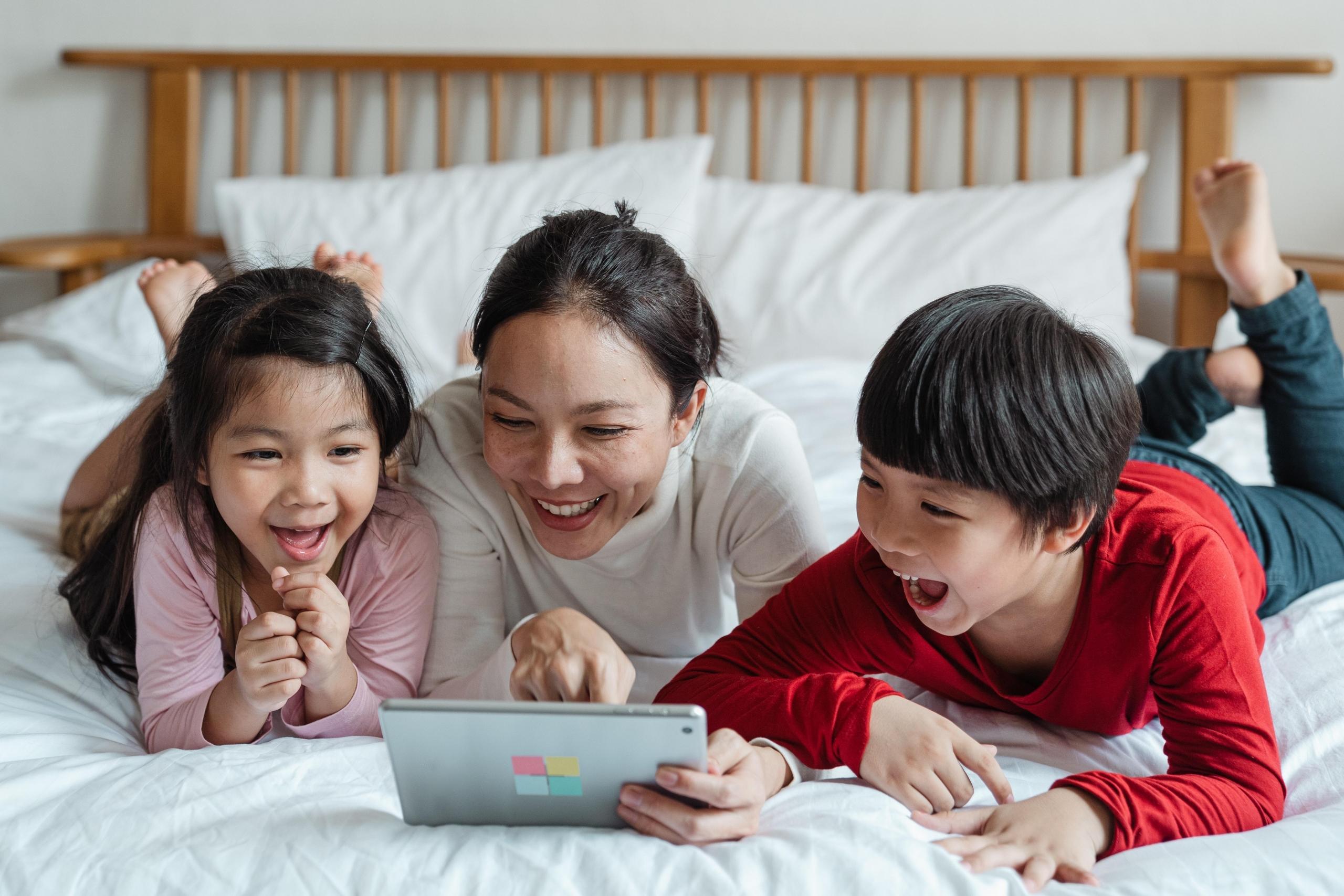 young family playing on tablet