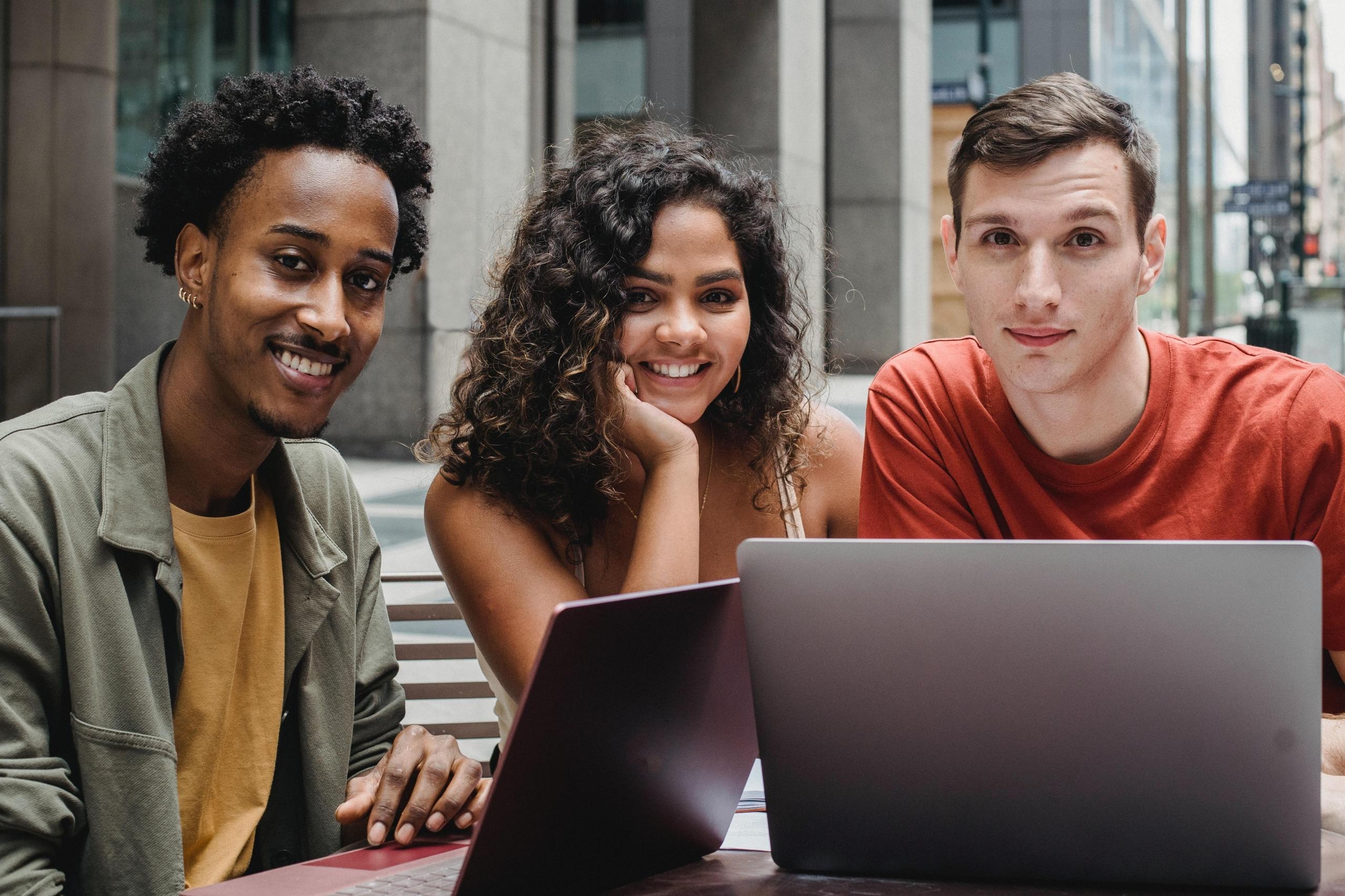 three students using laptops