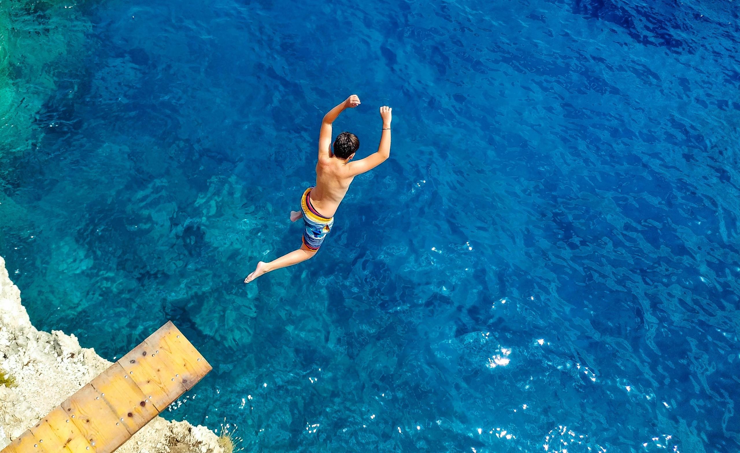 boy jumping off diving board