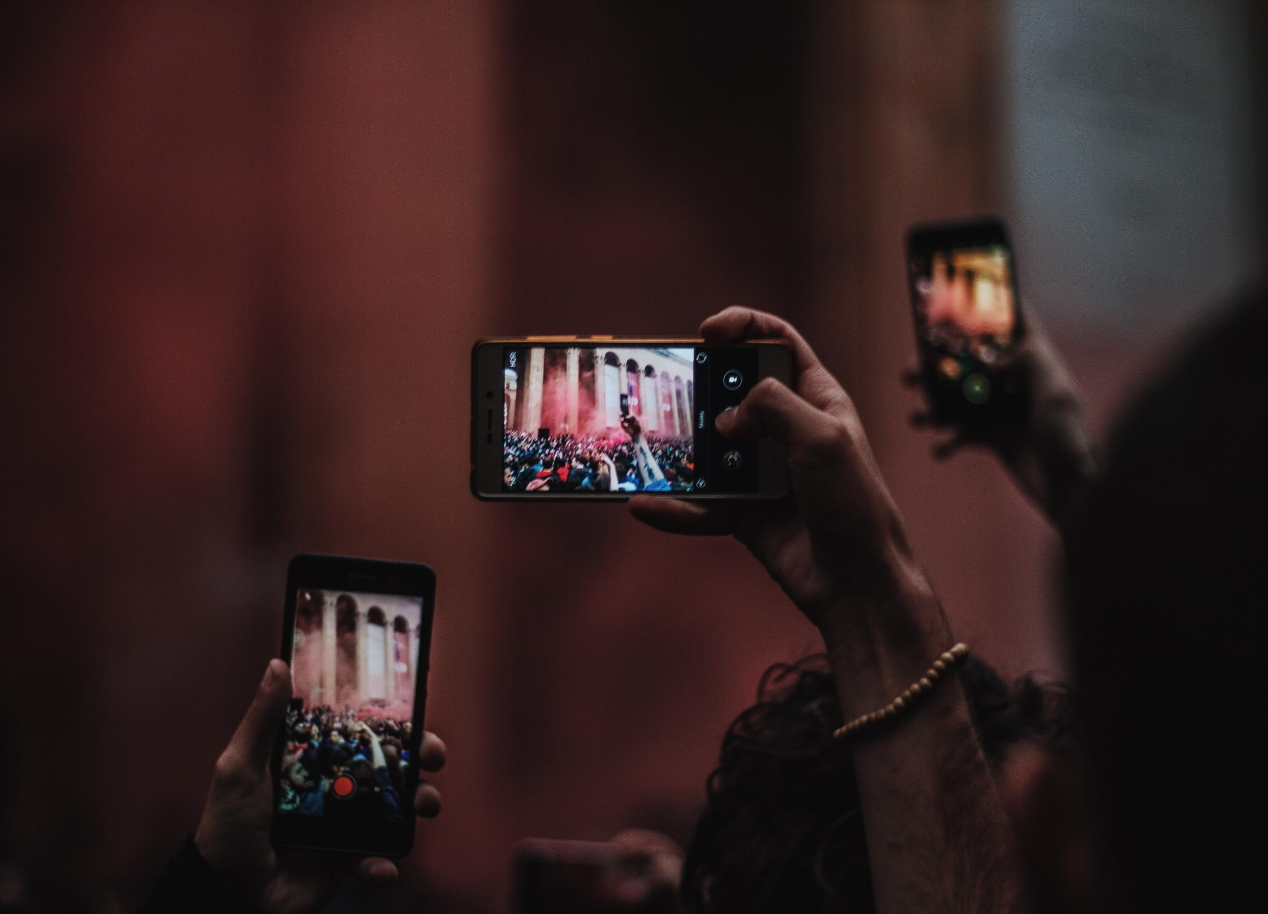 people using smartphone cameras in the dark