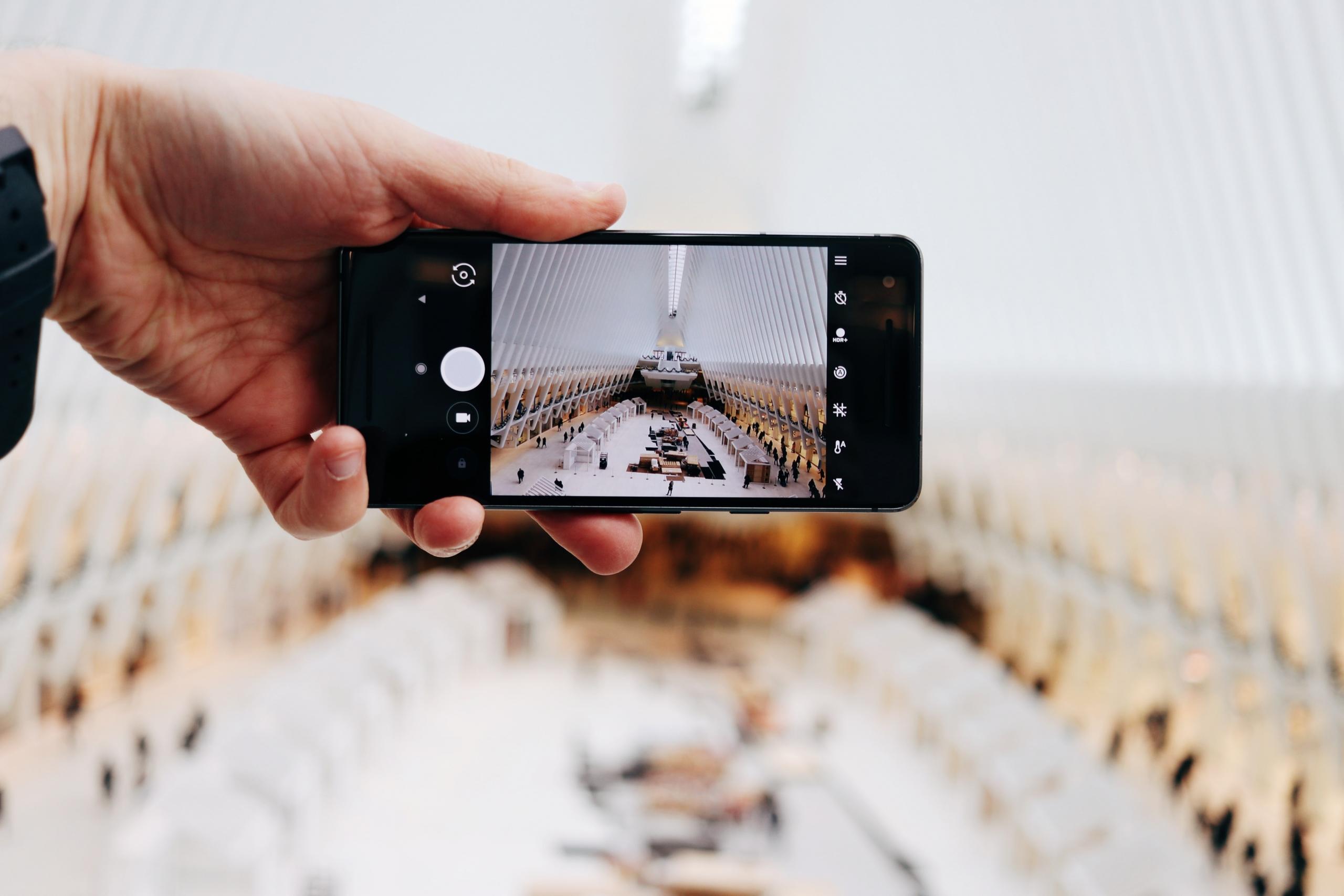 person using mobile phone camera to take photo of interior architecture