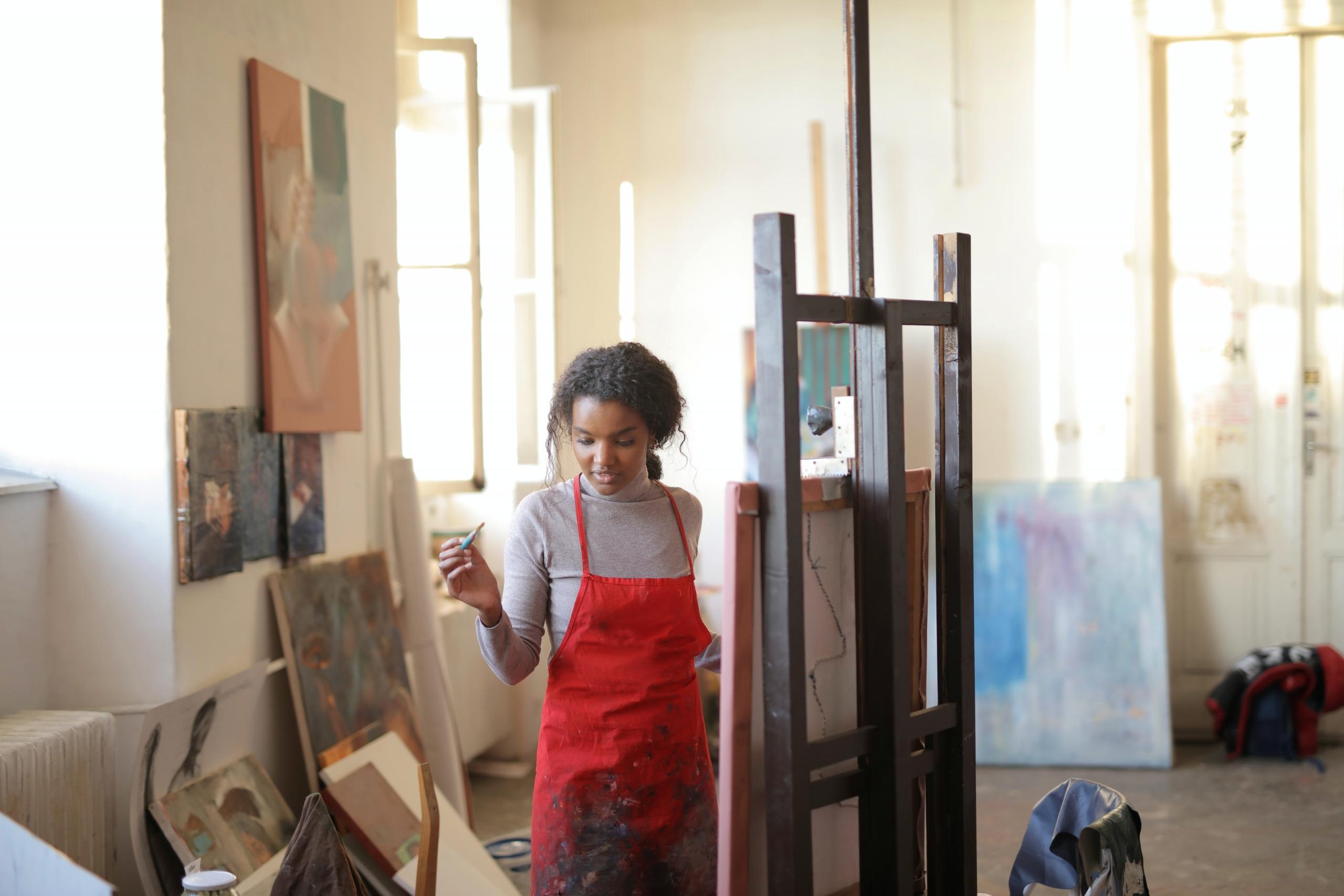 woman creating artwork on canvas in art studio
