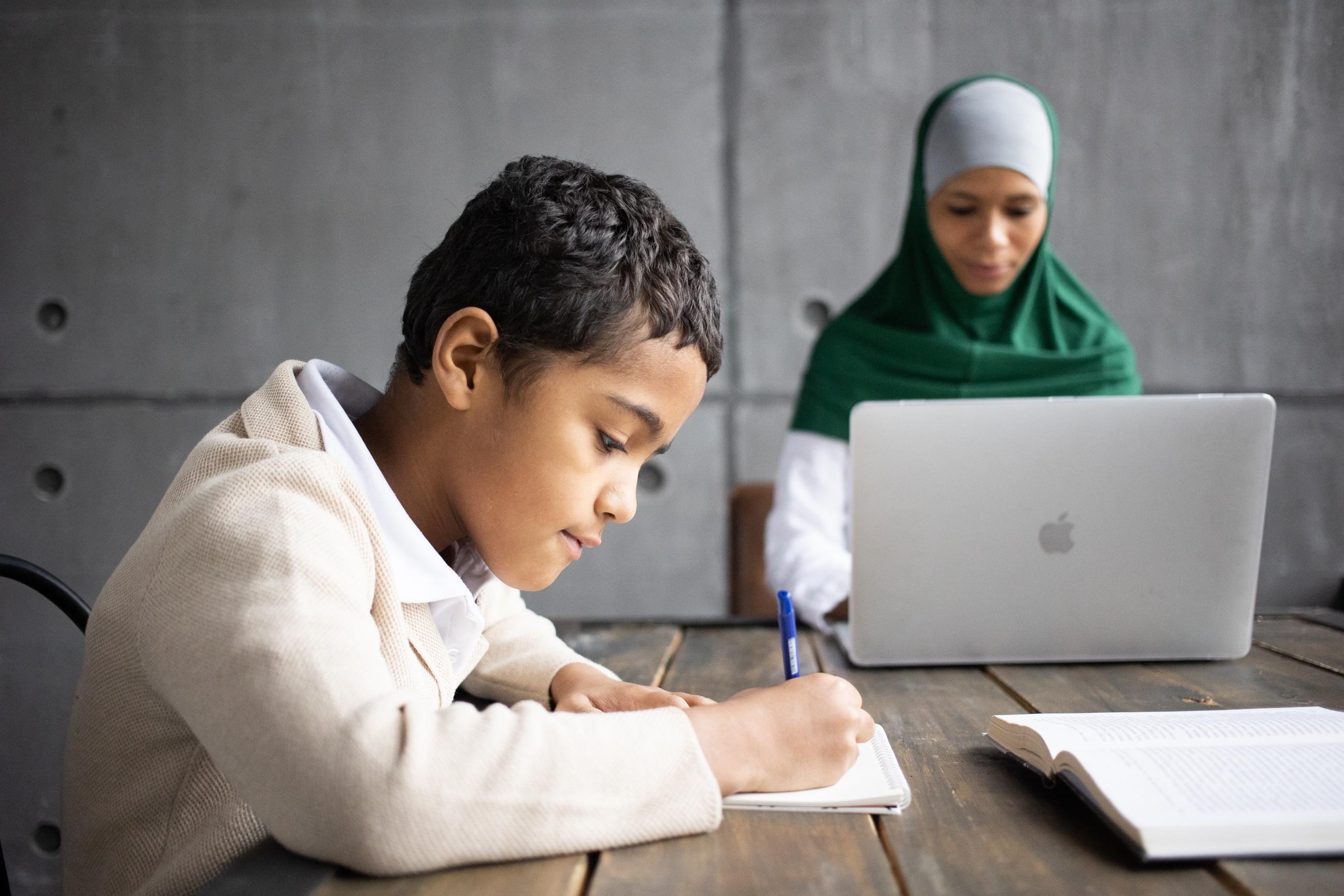 school boy studying with supervision of tutor