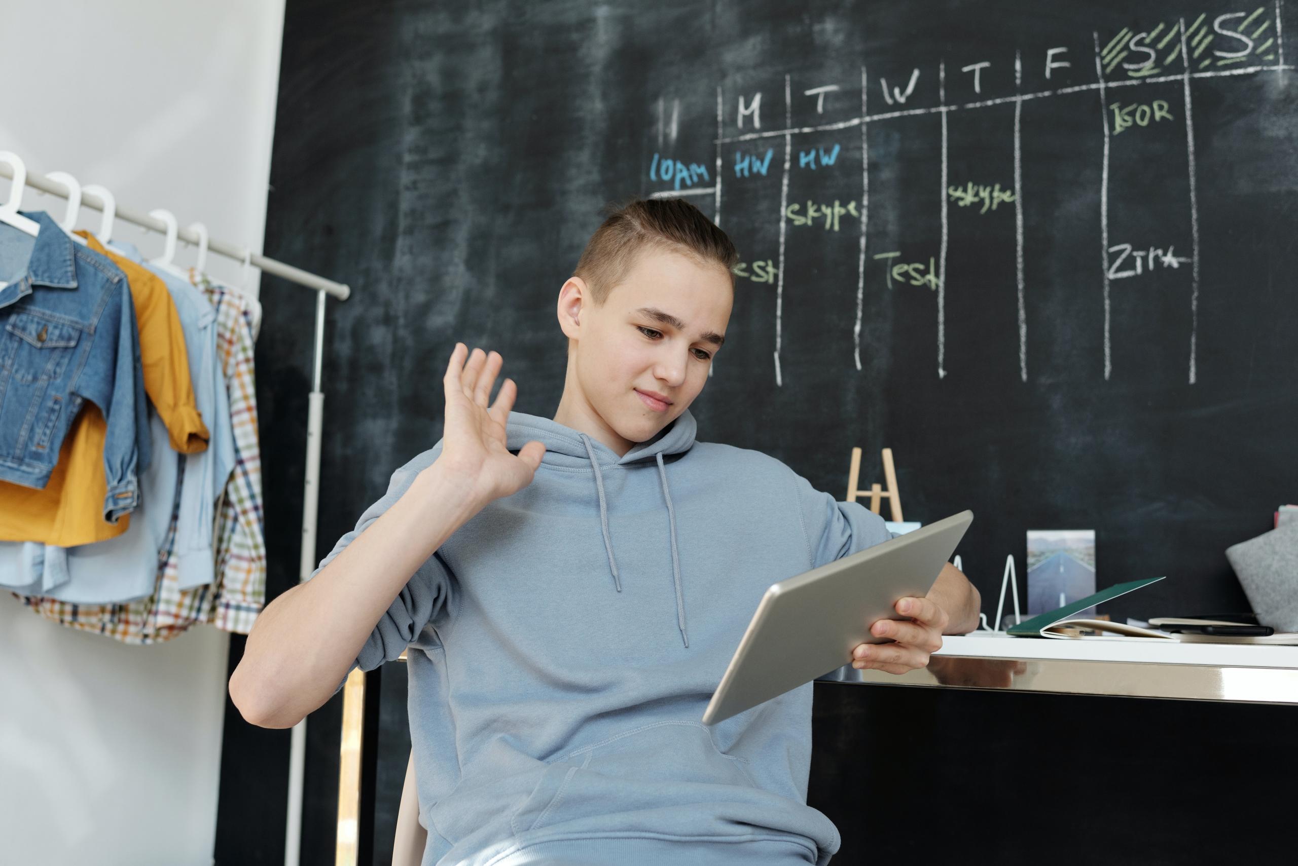 school boy sitting at desk doing homework