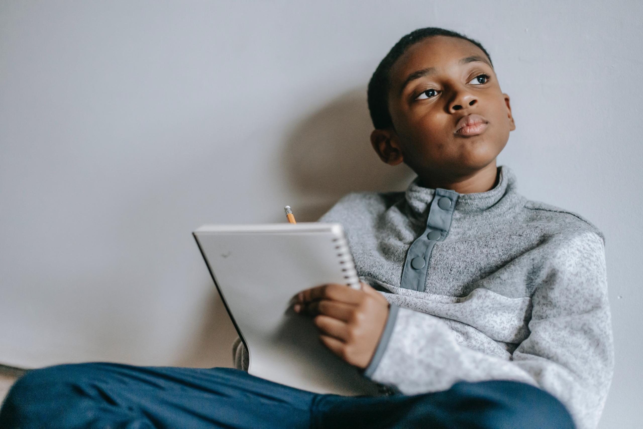 boy seated on floor doing homework