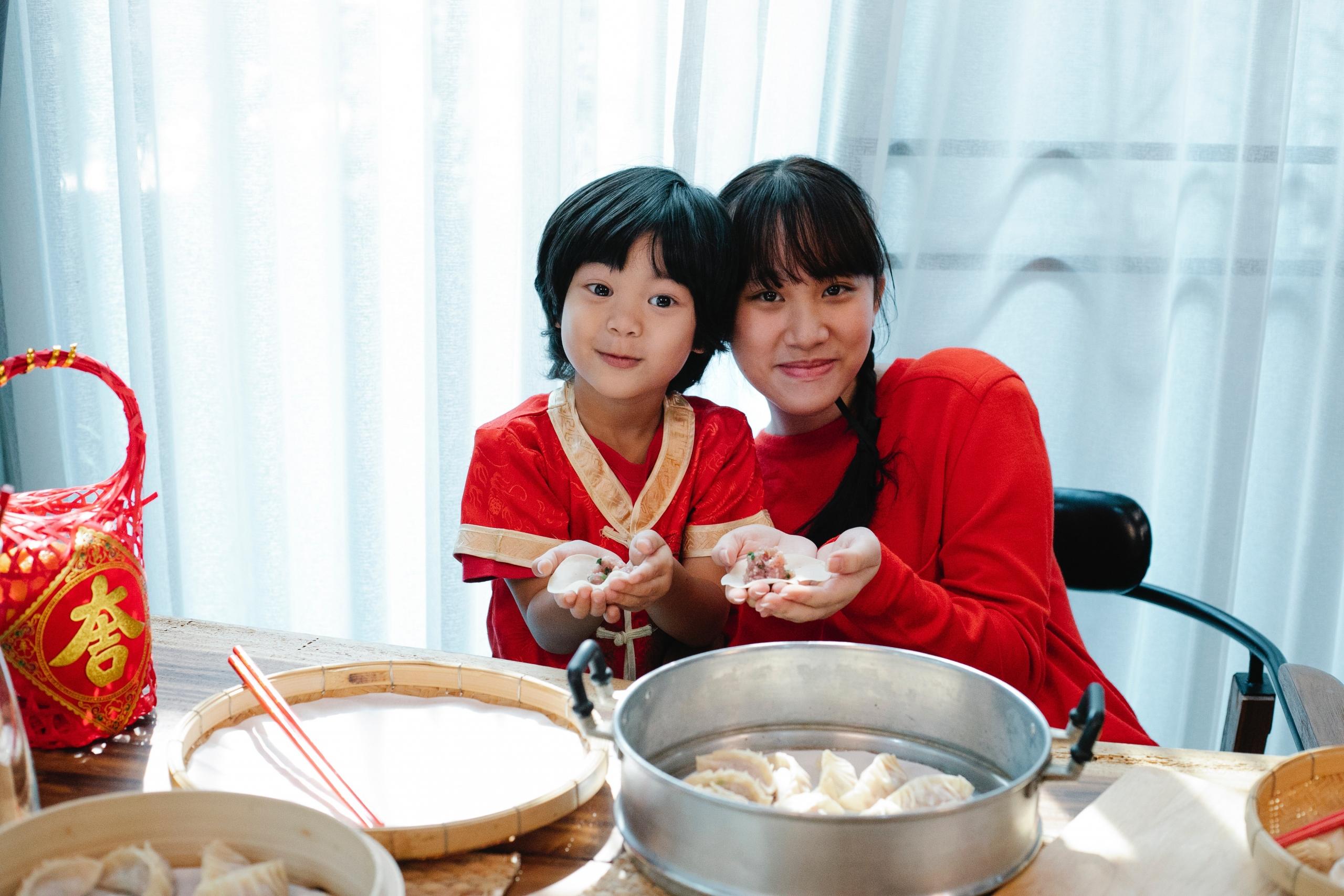 boy and girl making dumplings for Chinese New Year