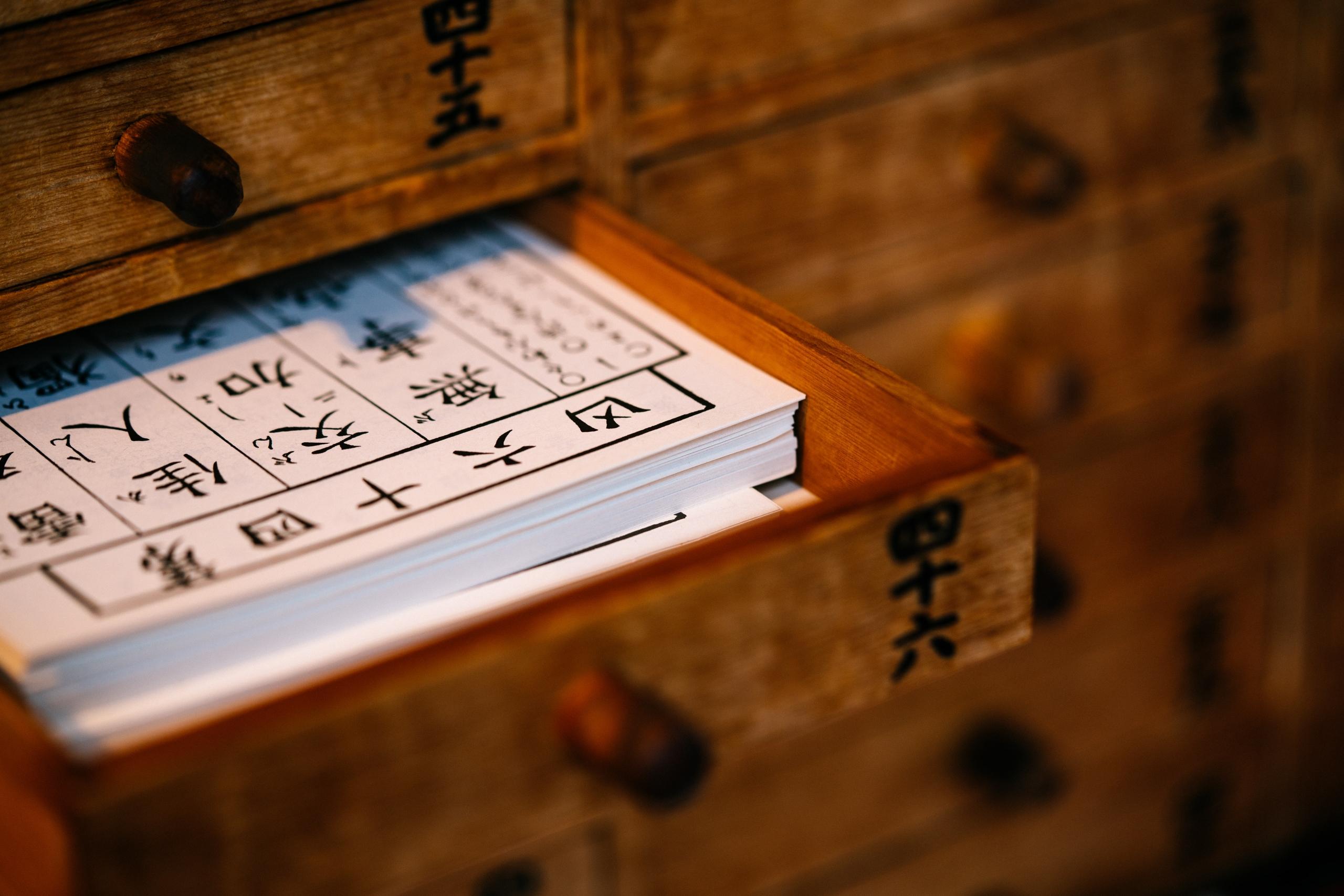 sheets of Chinese writing in wooden drawer