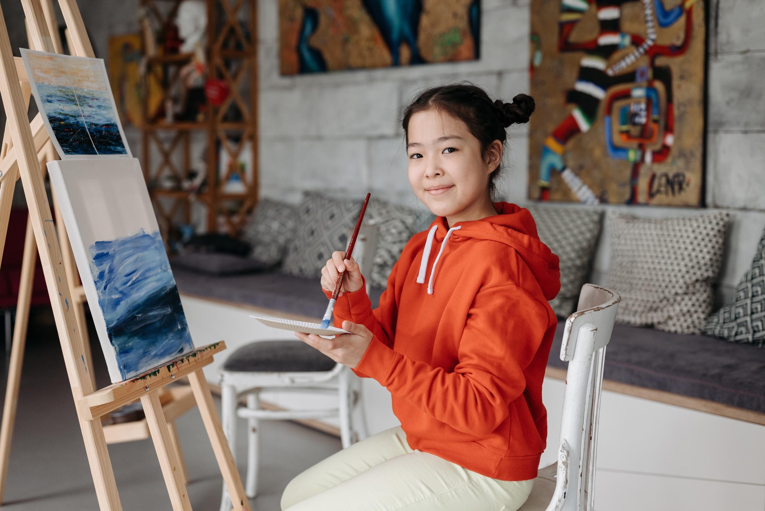 girl creating blue artwork in art studio