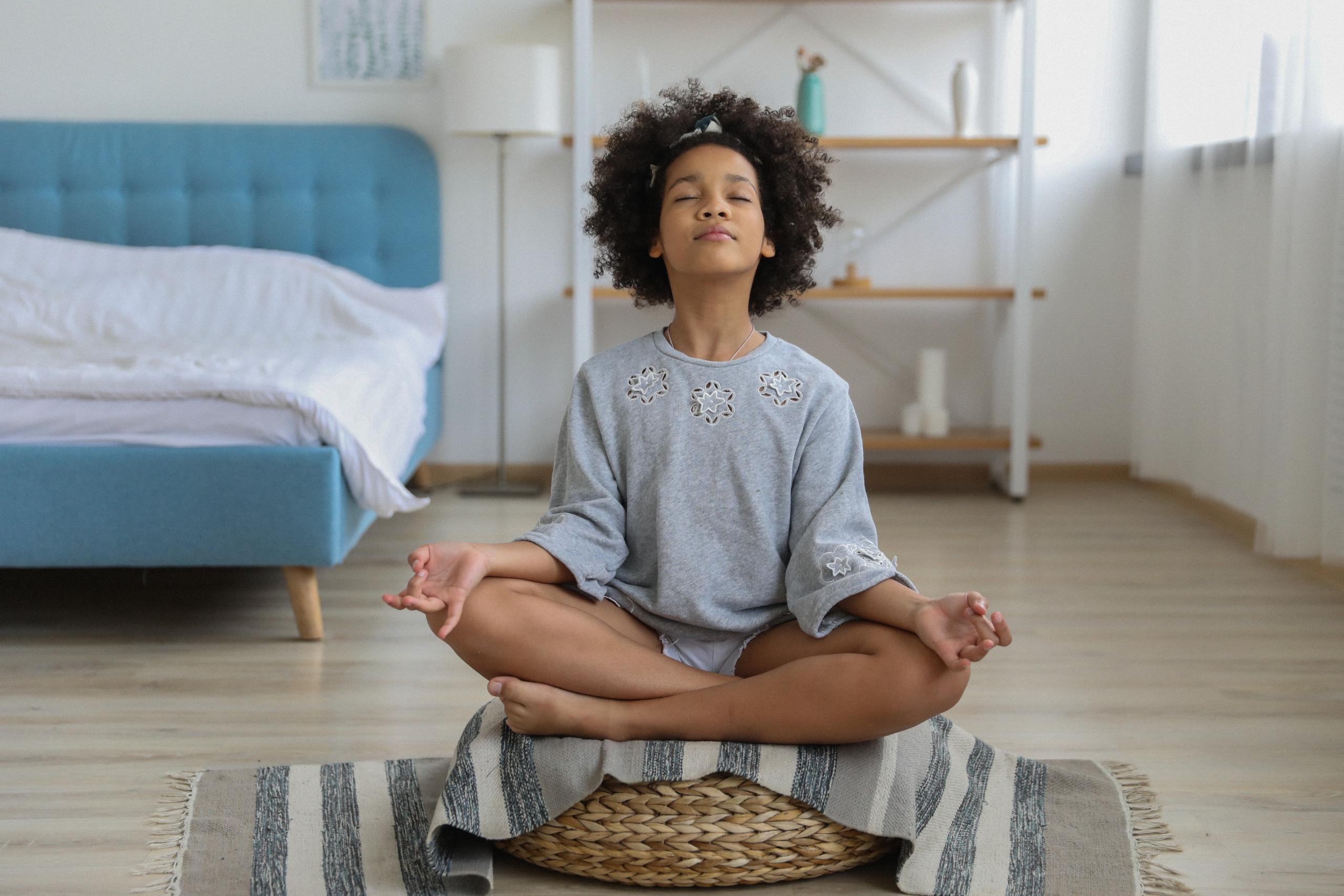 girl practising meditation in bedroom