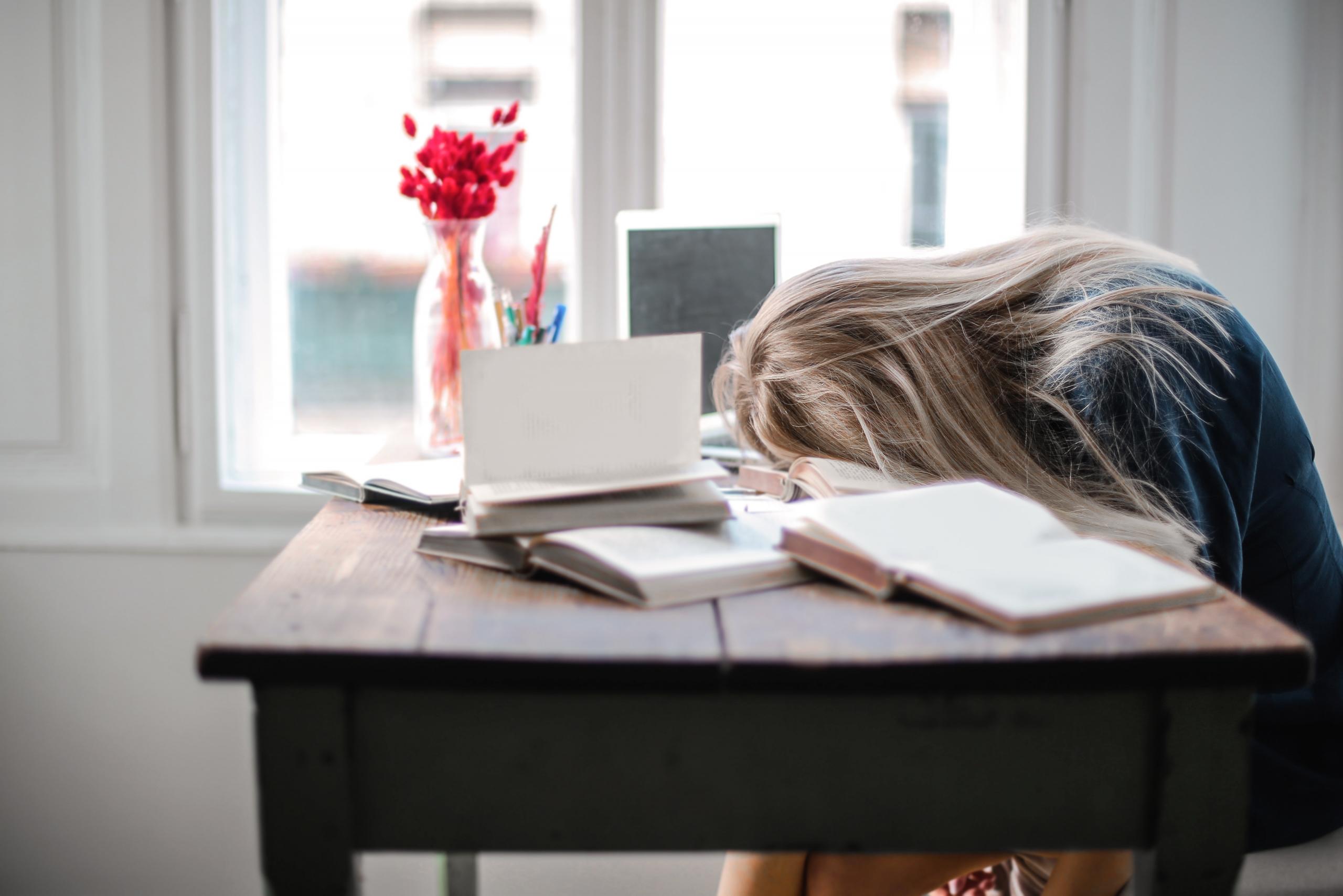 tired student sleeping on books