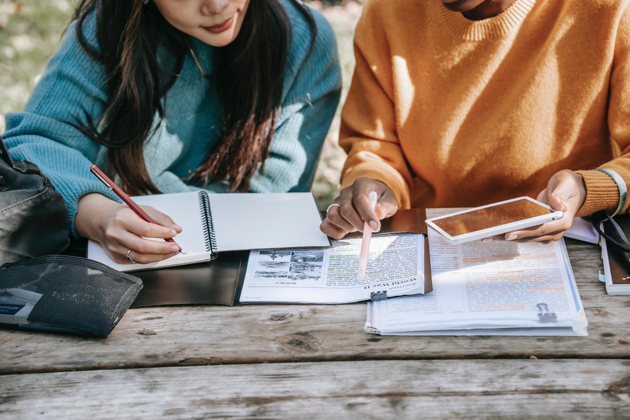 two girls revising their notes together