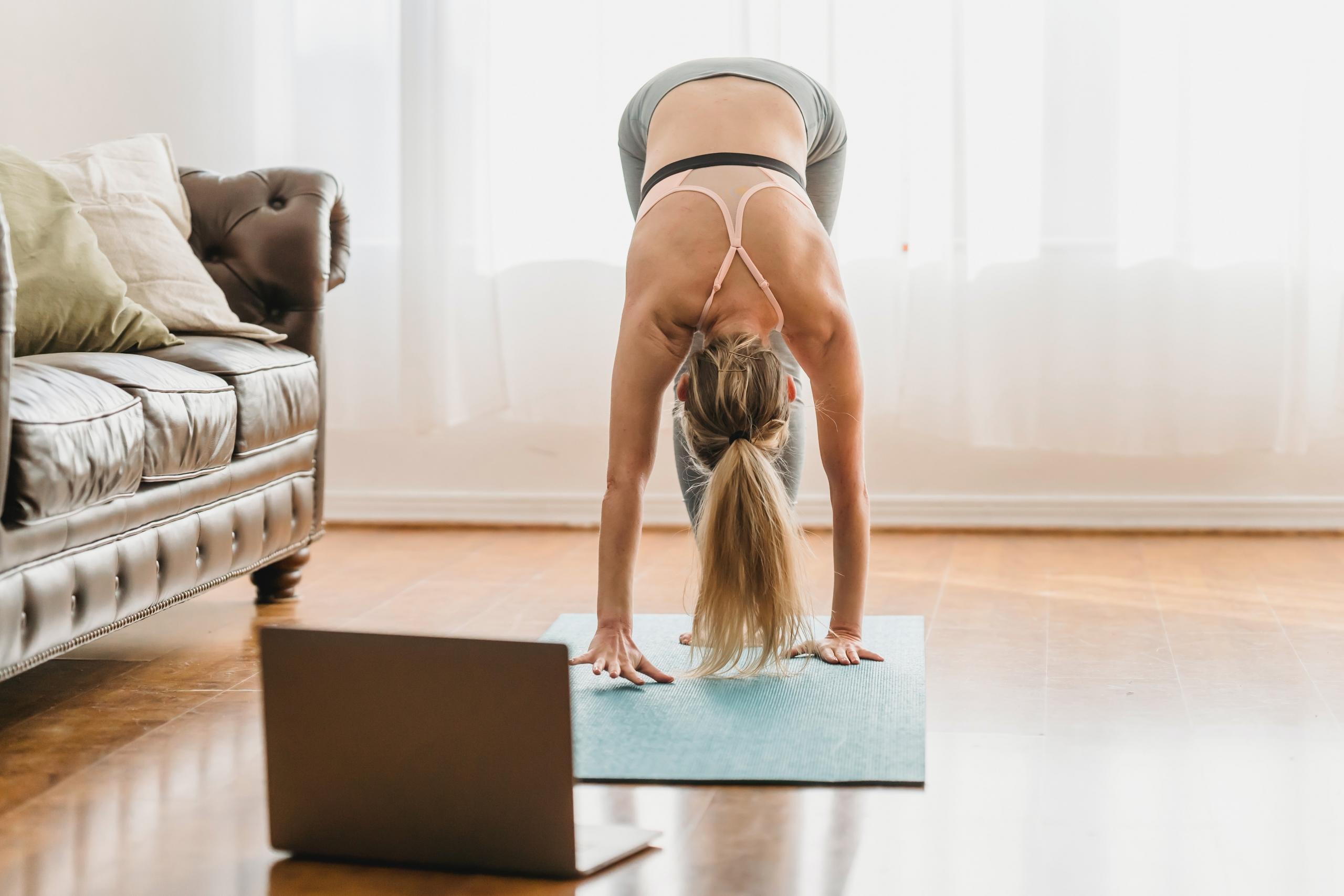 woman doing yoga using laptop