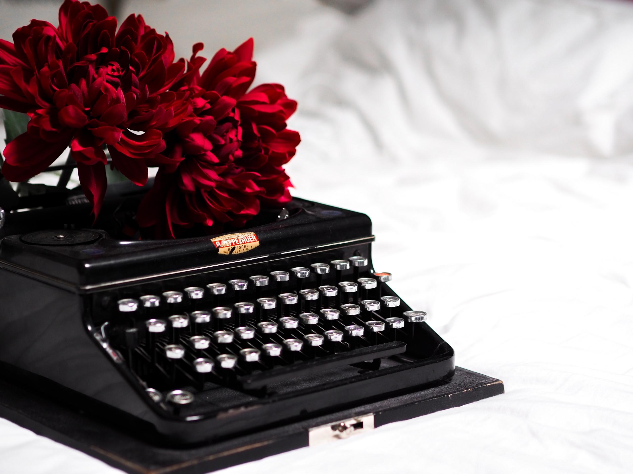black typewriter on white bedlinen