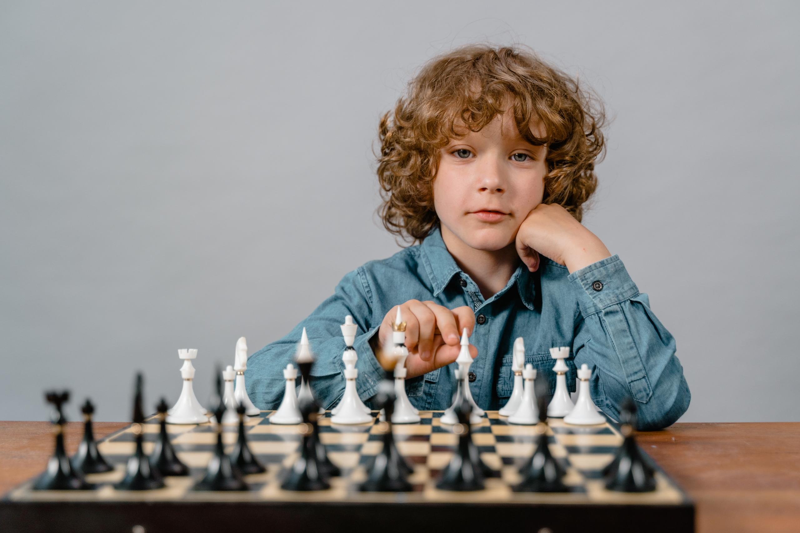 boy learning to play chess