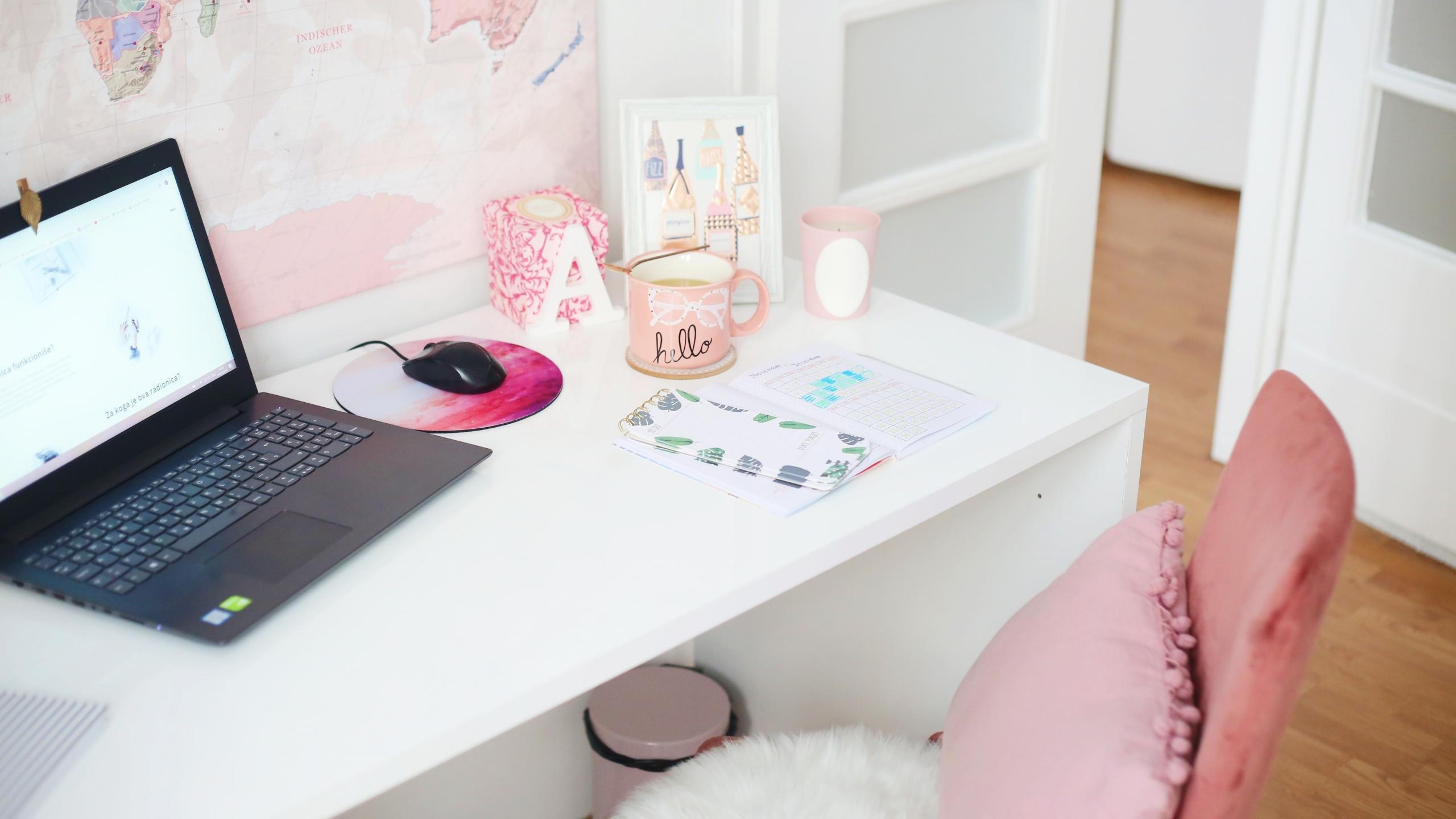 laptop on white desk, with pink accents