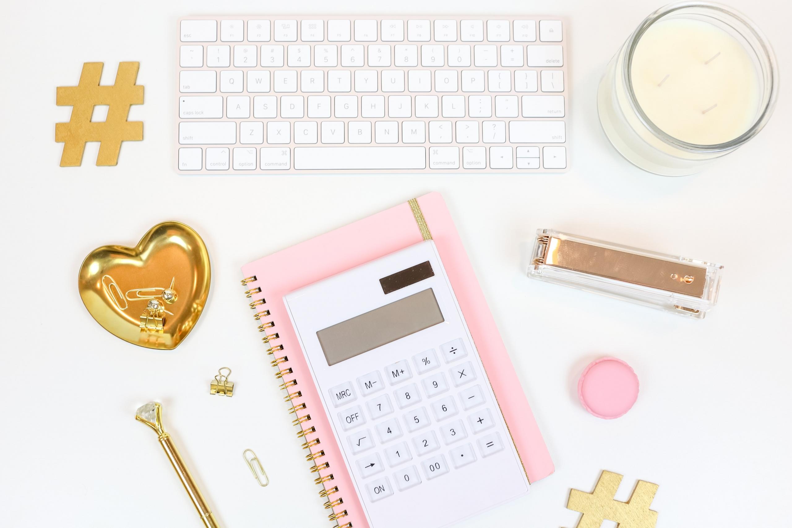 calculator, notebook and keyboard on white desk