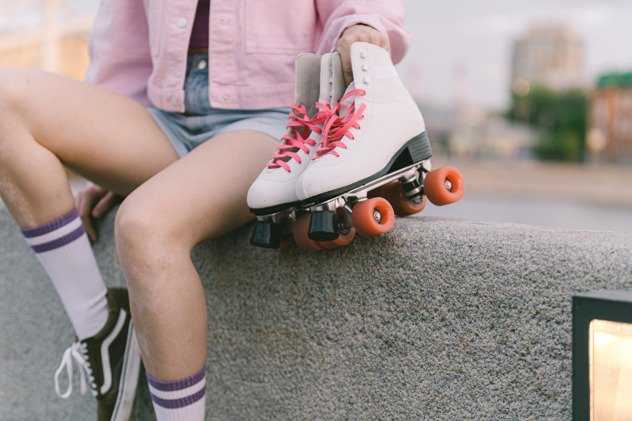 girl holding a pair of roller skates