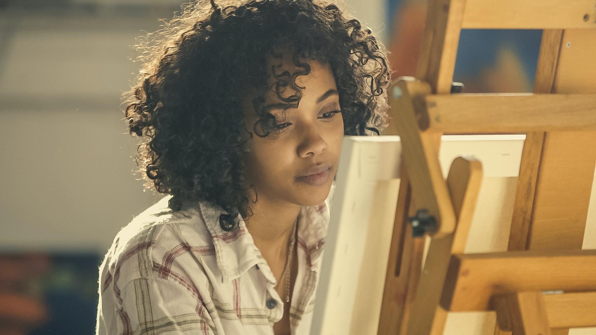 artist painting on canvas and easel