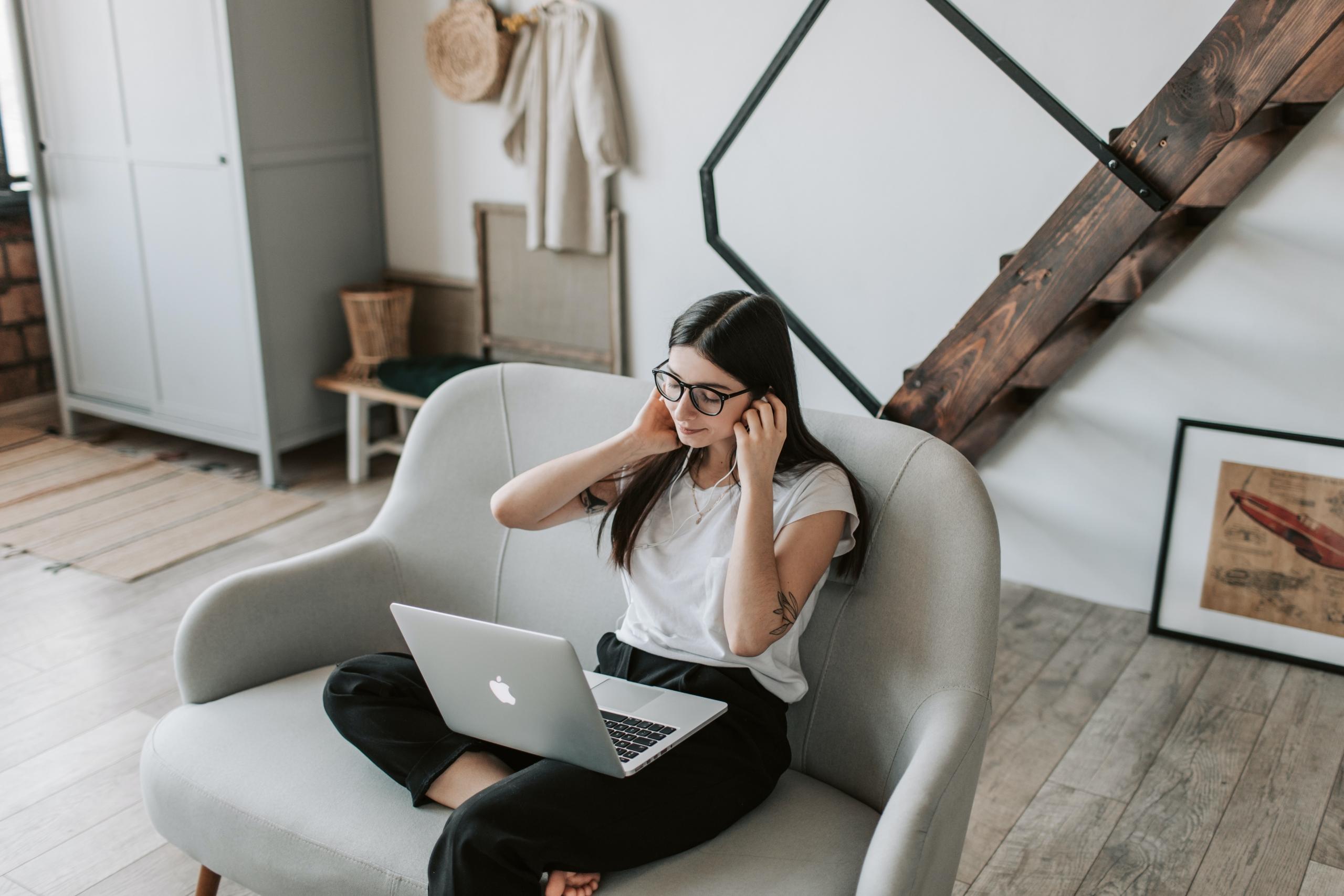 girl using earphones and laptop for online lessons