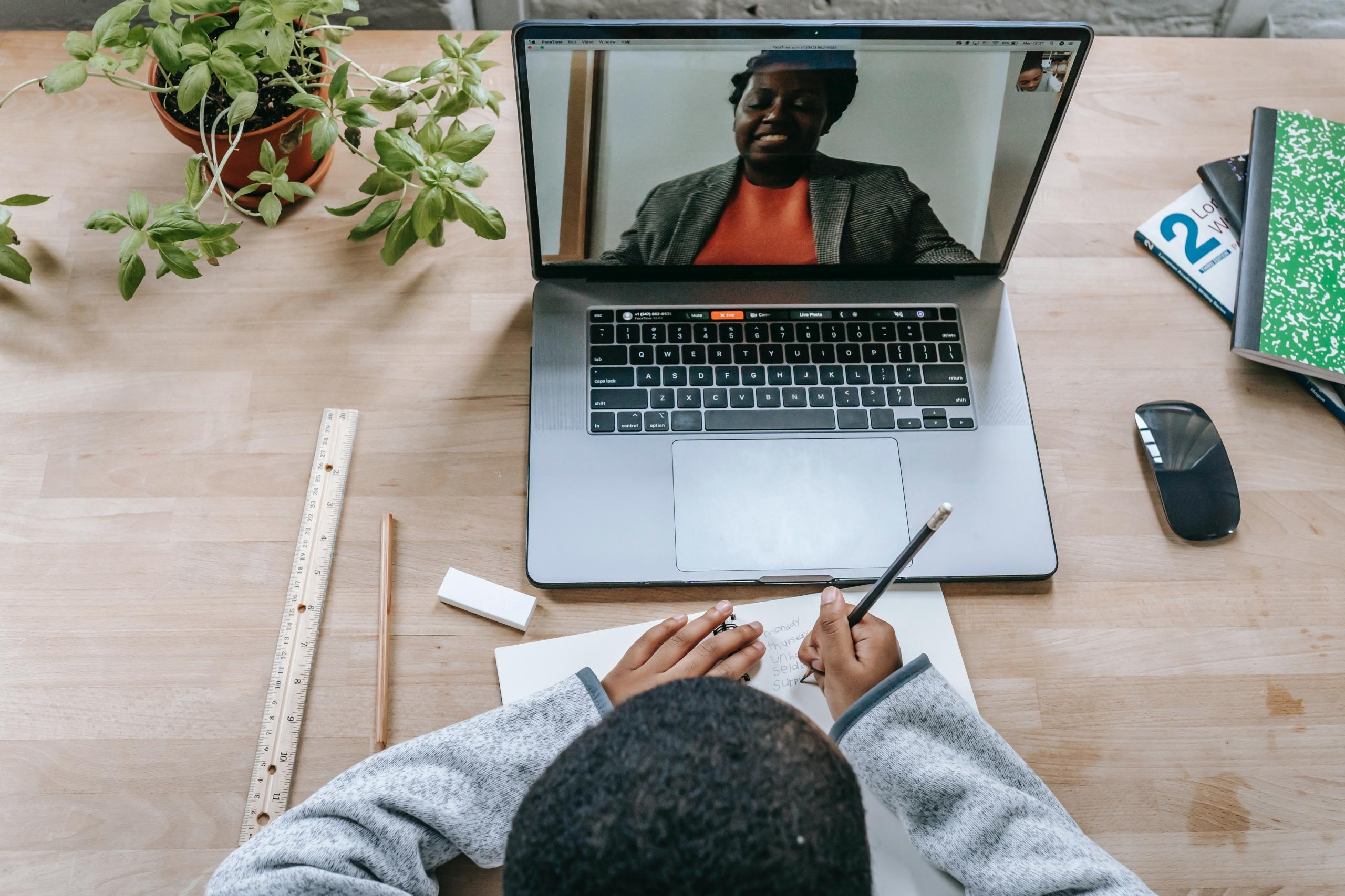 teacher and student in online lesson on laptop