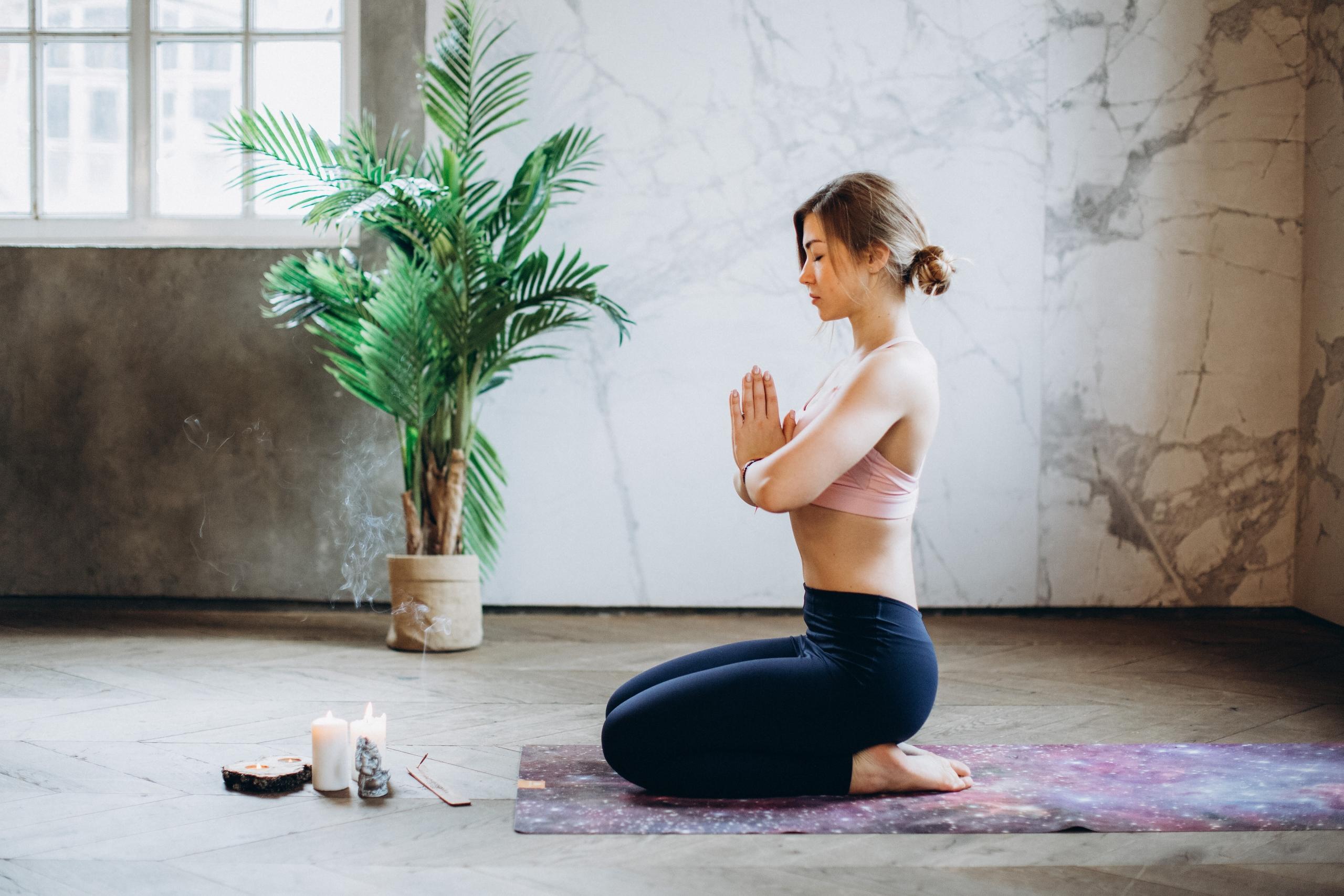 woman on yoga mat practising meditation