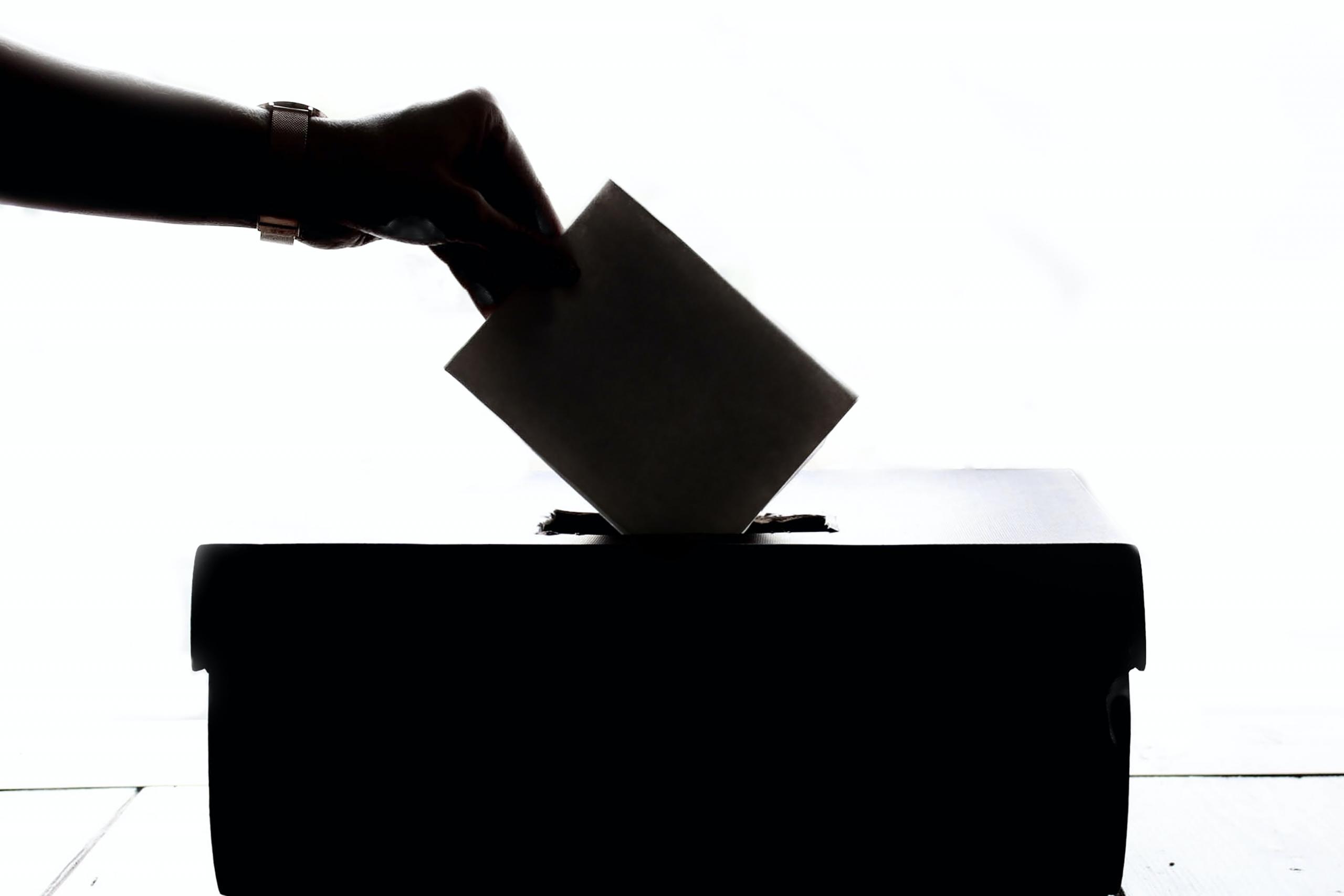 woman placing ballot paper in voting box