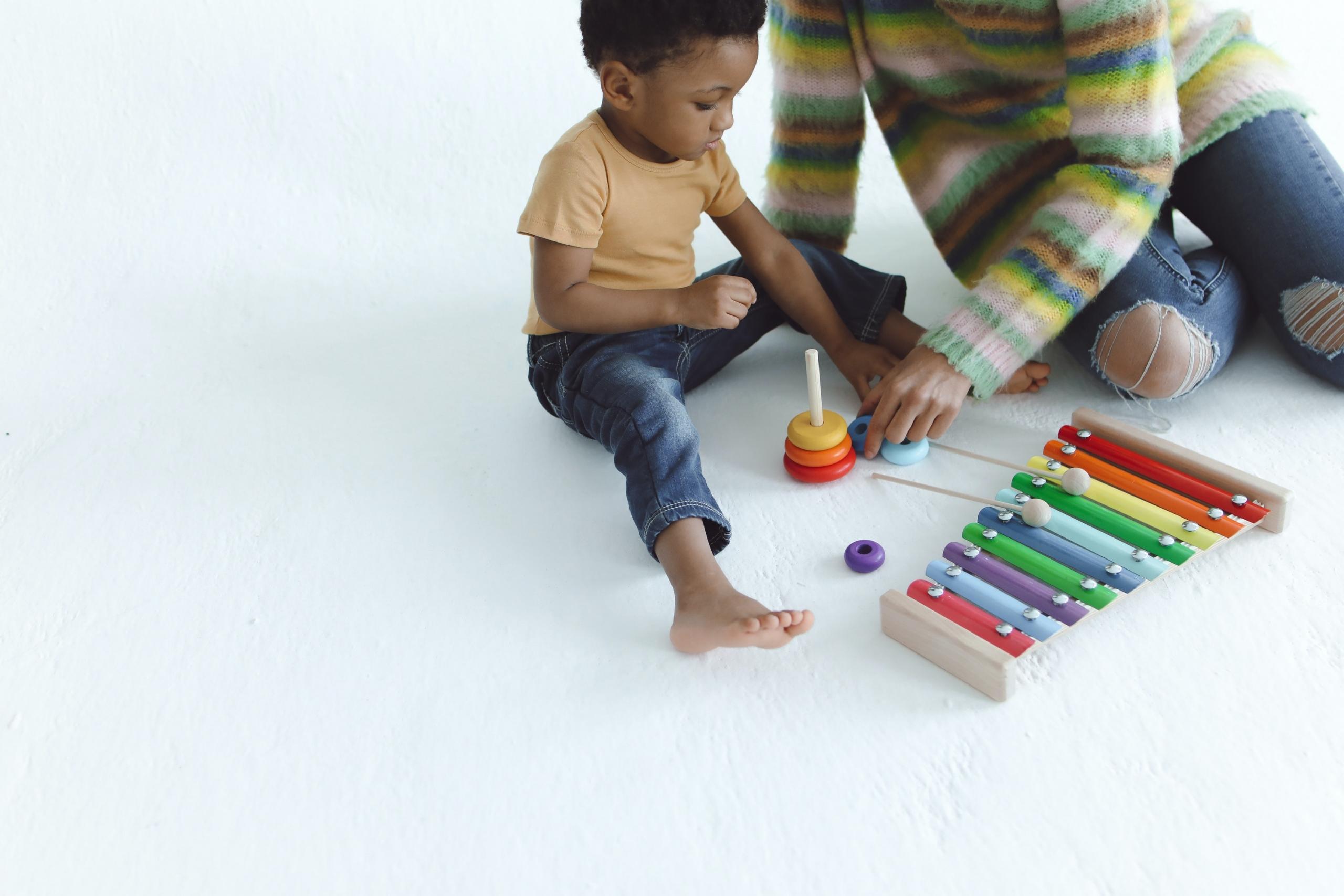 mom teaching son to play the xylophone