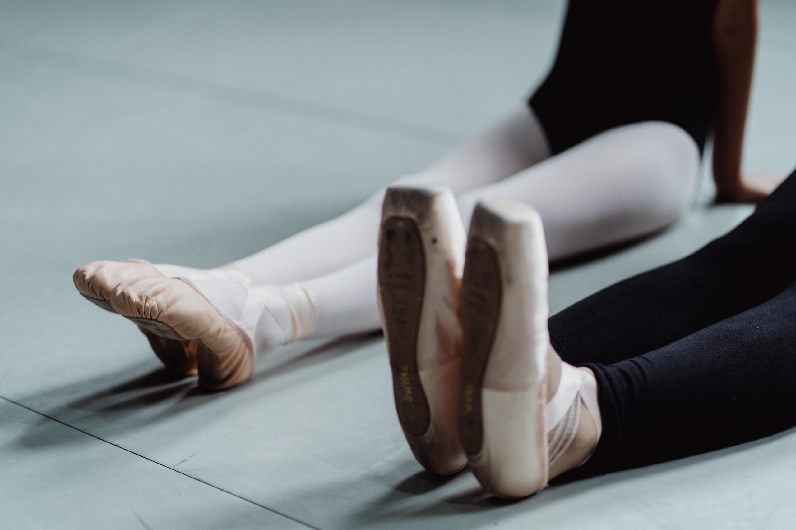 ballet teacher teaching ballerina how to point toes