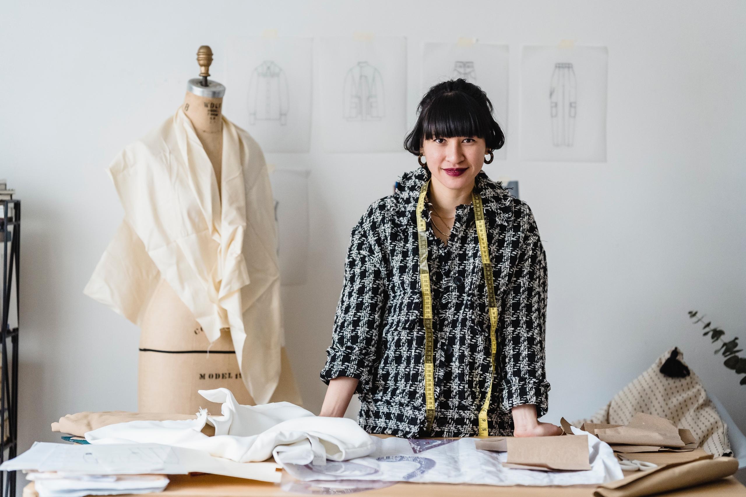 dressmaker with tape measure draped around neck